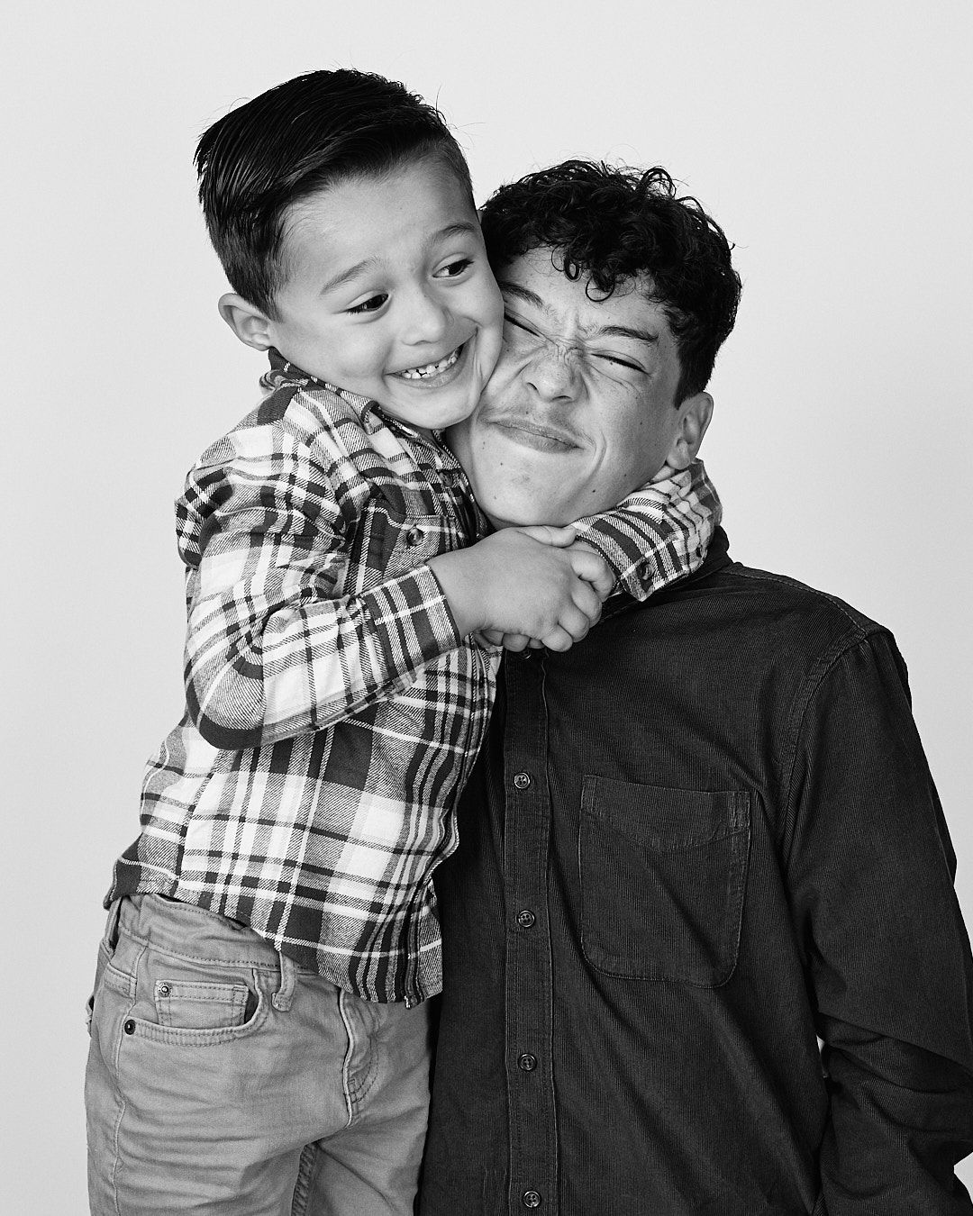 Candid black and white photos of father and son sharing affectionate moments together.