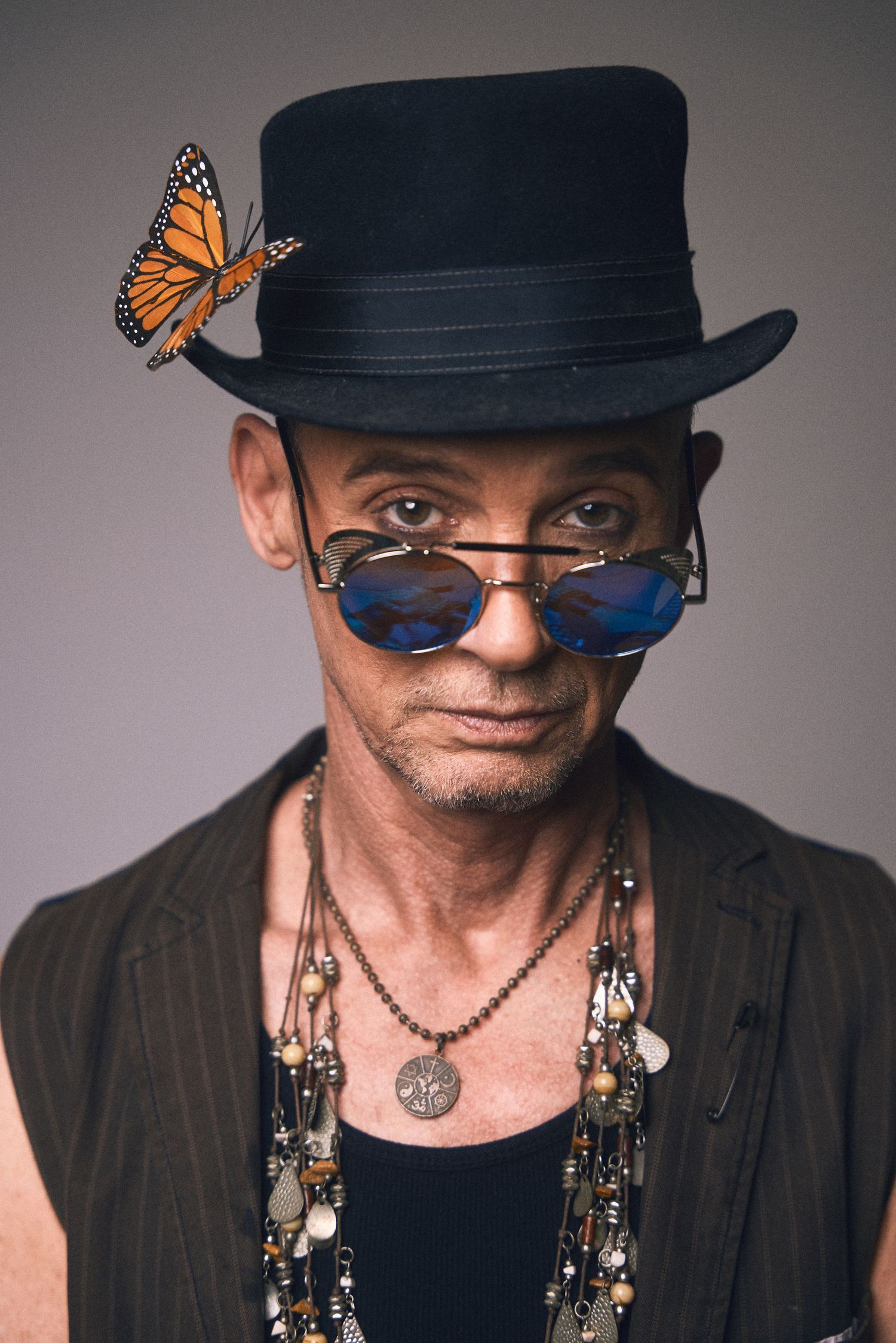 Artistic portrait series featuring someone in a black hat with butterfly and jewelry details.