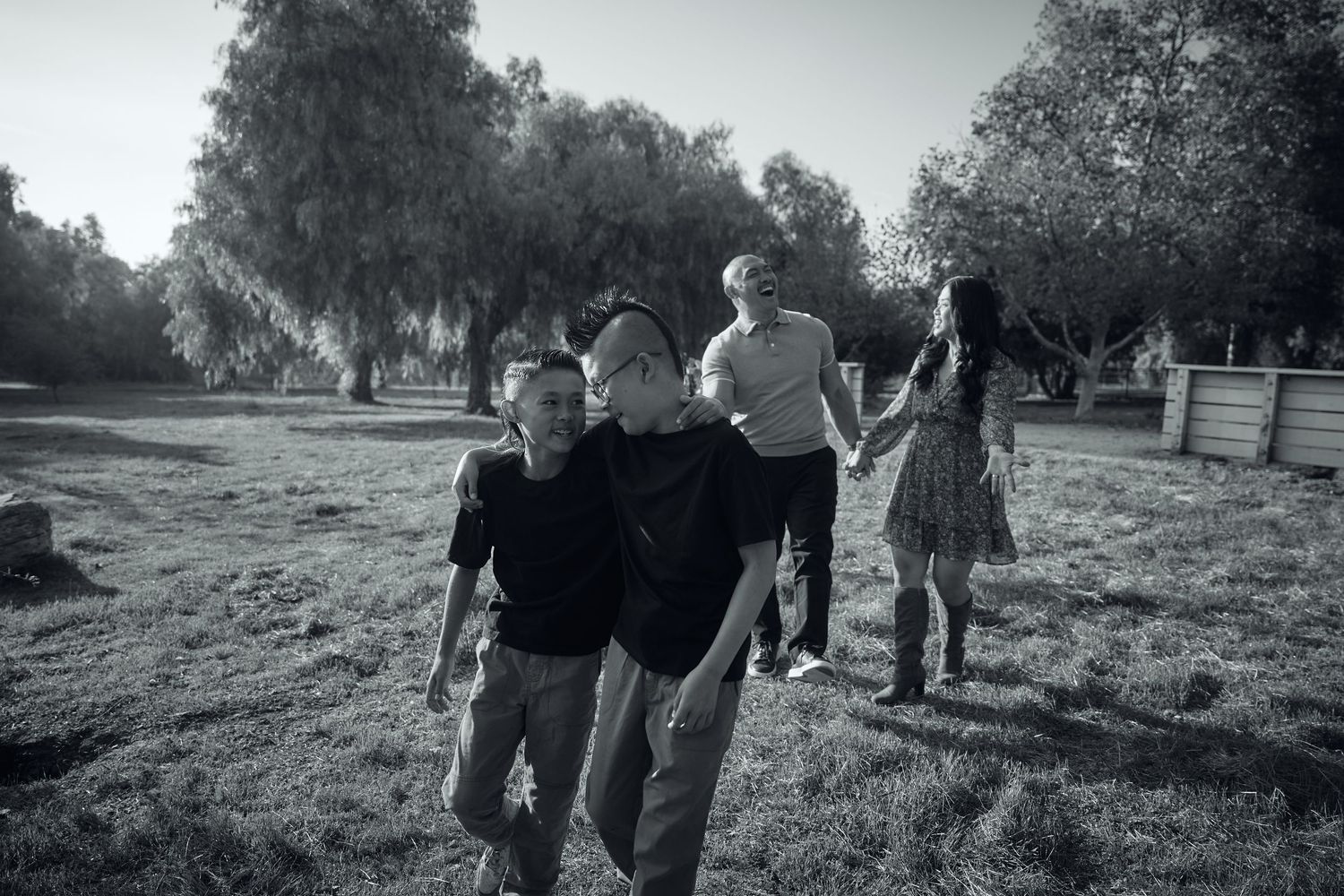 Black and white outdoor family photography session under trees.