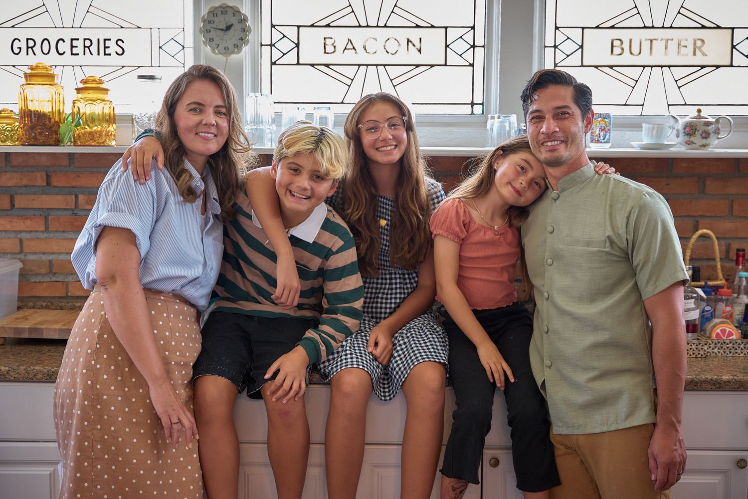 Group photo in a vintage-styled grocery store setting with retro signage in the background.