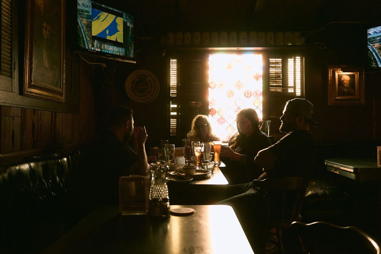 Silhouettes of people gathered in a dark room with ambient lighting.