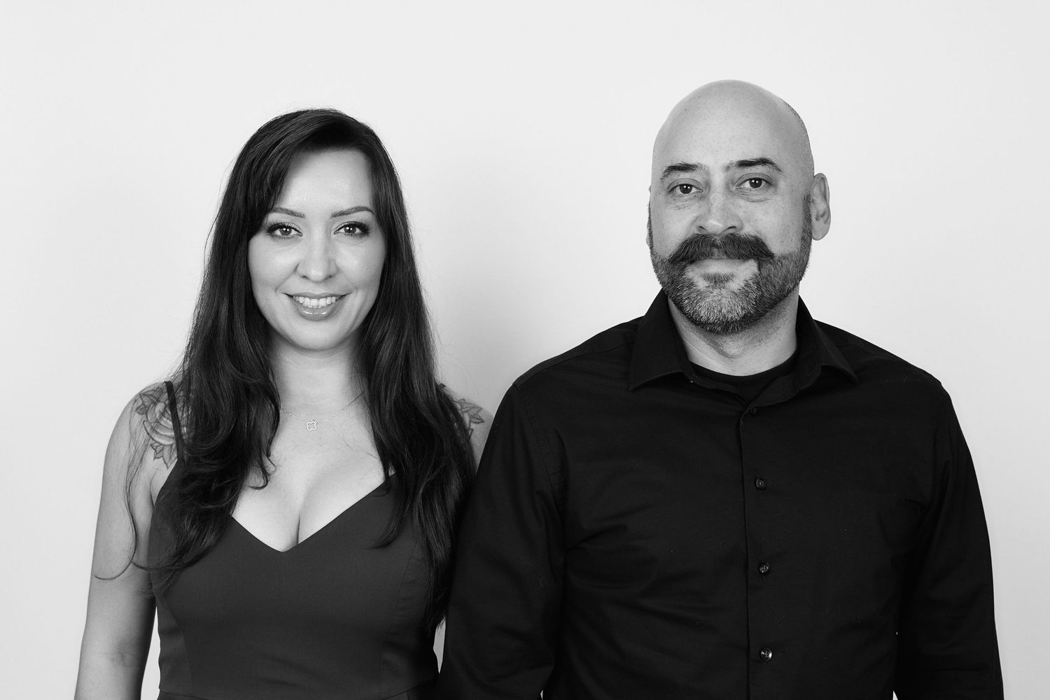 Professional studio portraits of a couple in black attire against white background.