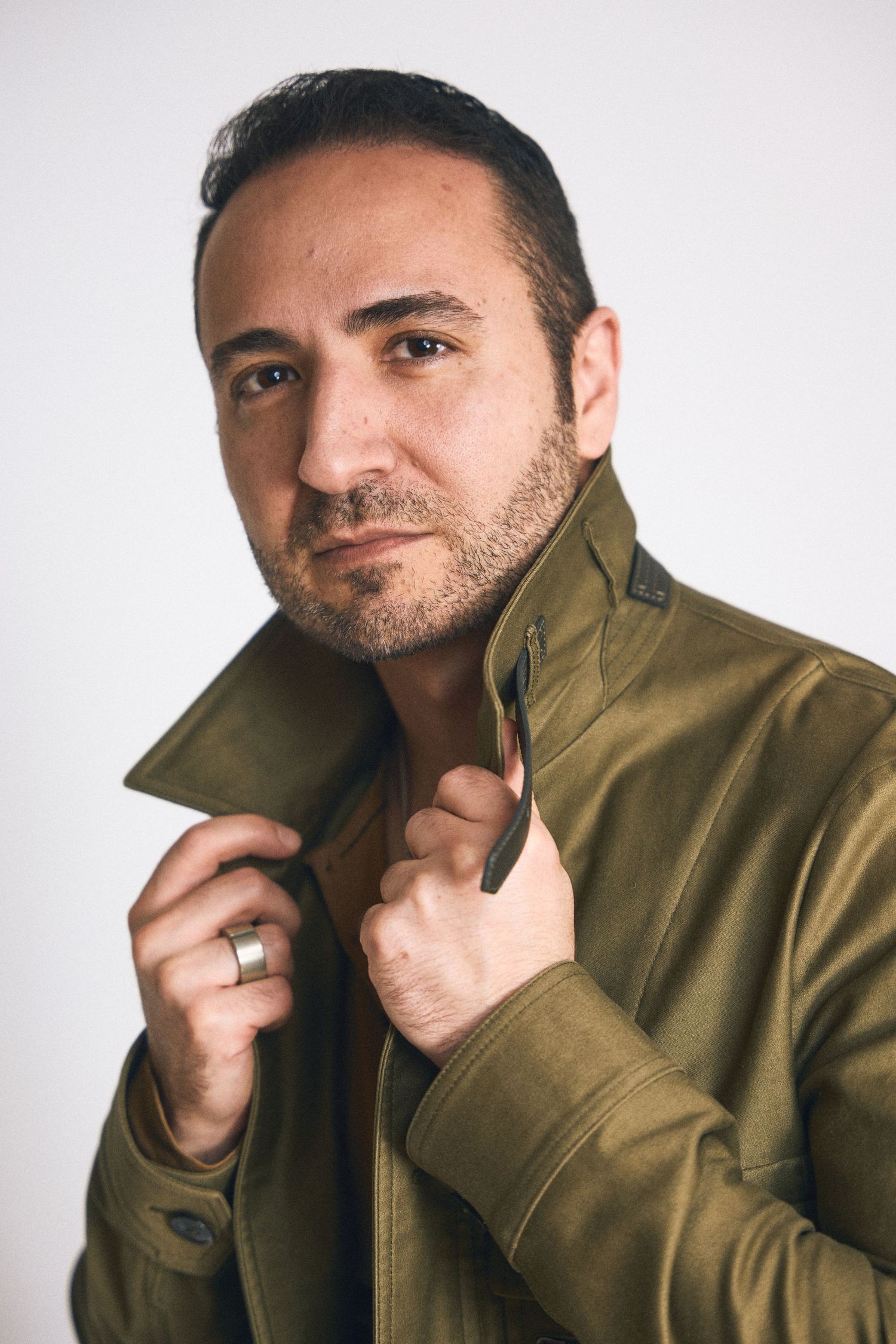 Studio portraits in olive jacket showing different angles and expressions.