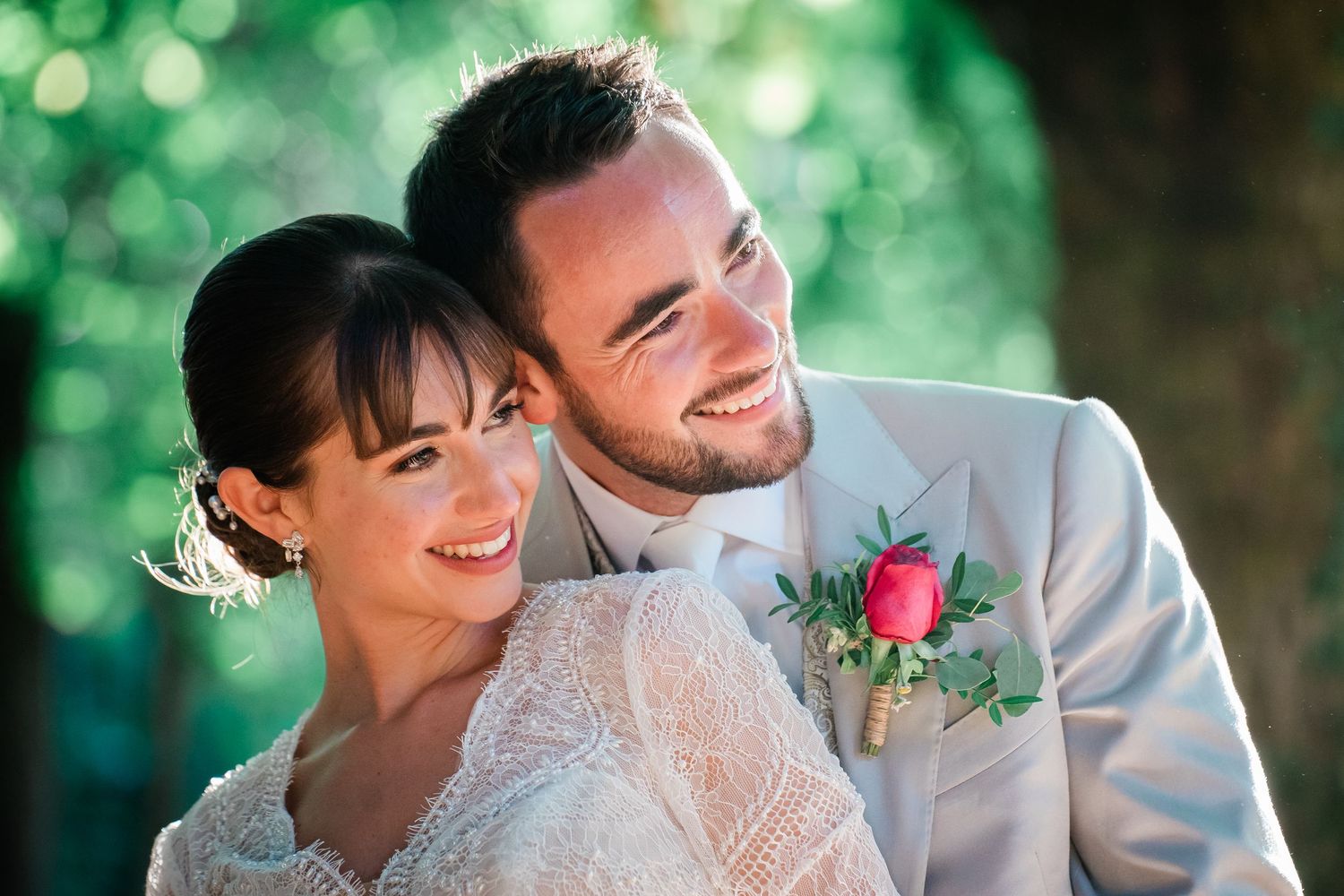 Close-up portrait of newlyweds sharing a happy moment in natural outdoor lighting.