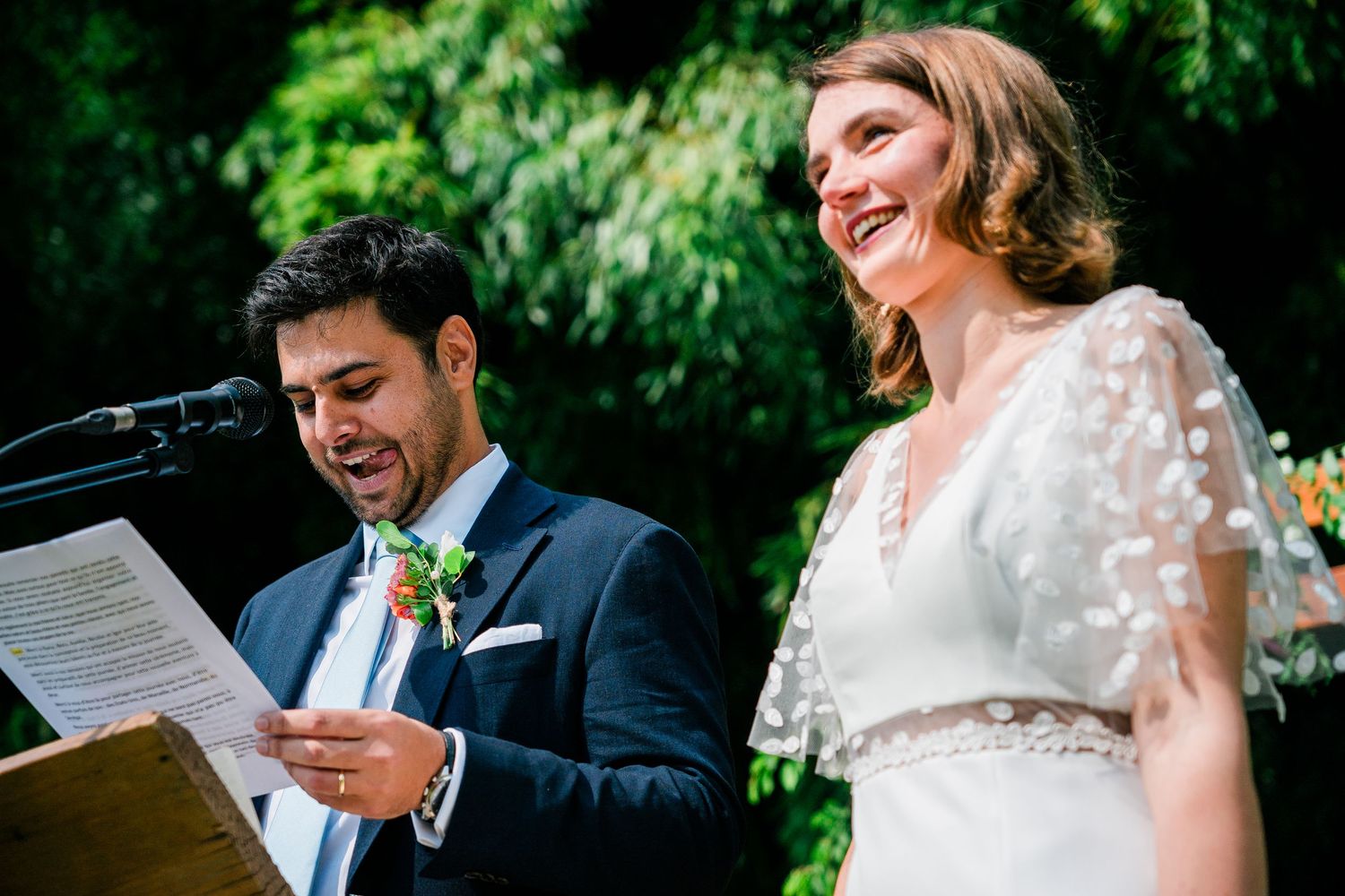Joyful wedding ceremony moment with couple sharing laughter during vow readings.