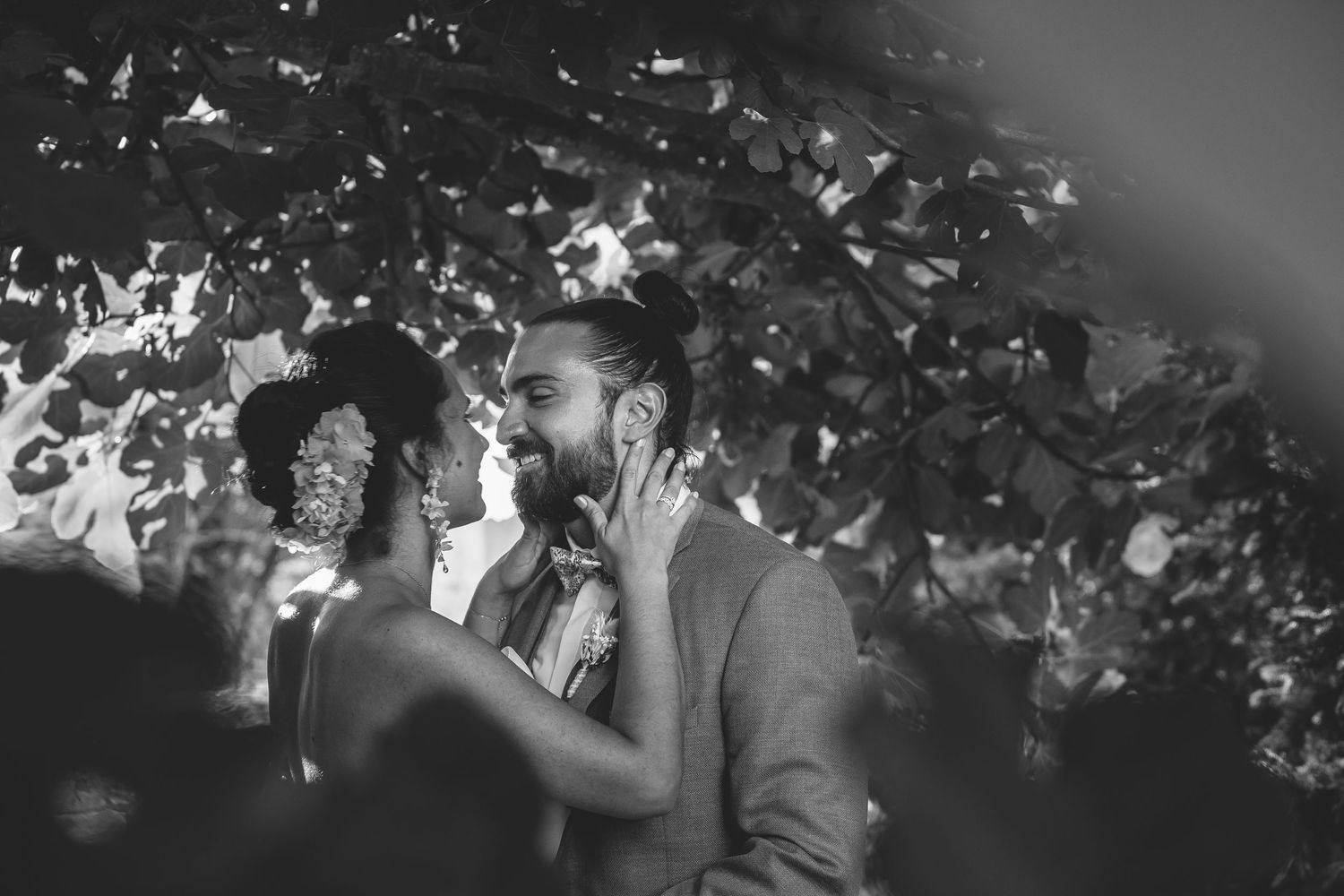 A romantic black and white photo of a couple sharing an intimate moment under twinkling lights.