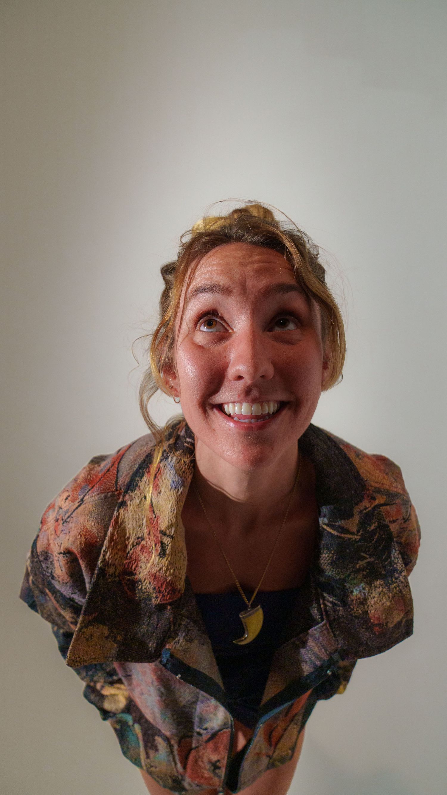Person in a vintage-style patterned jacket makes expressive poses in a photo series.