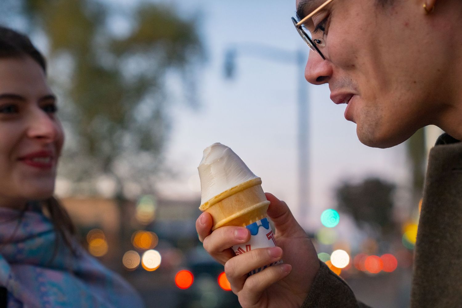 Close-up view of someone enjoying ice cream cones on a sunny day.