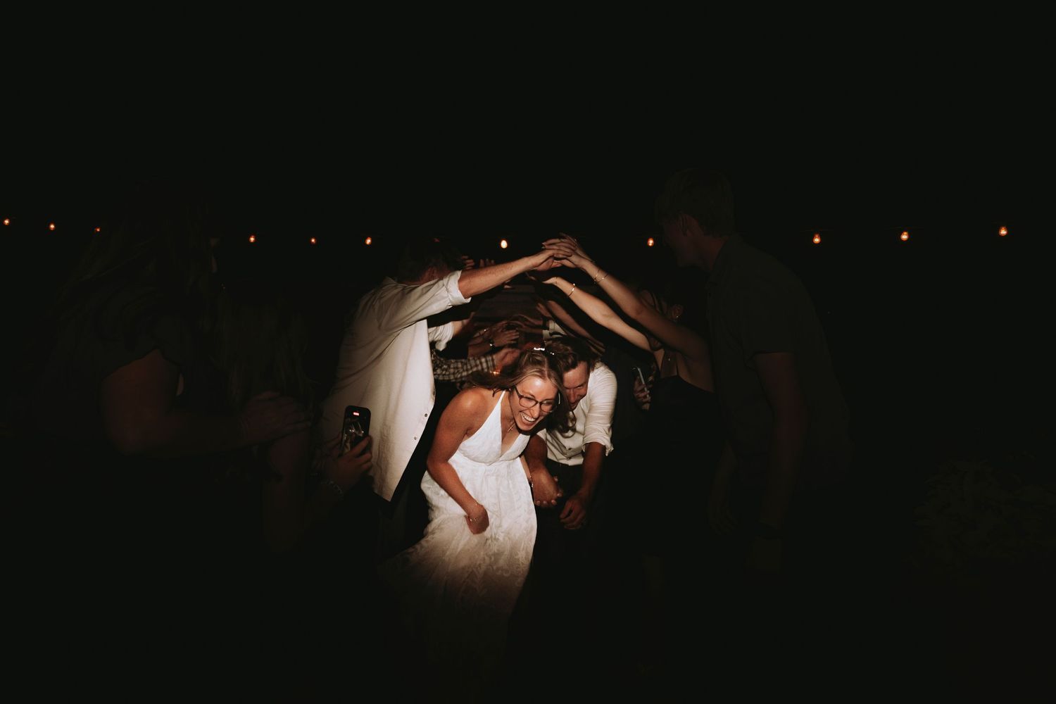 A wedding couple in a dark atmospheric nighttime scene with subtle lighting and shadowy ambiance.