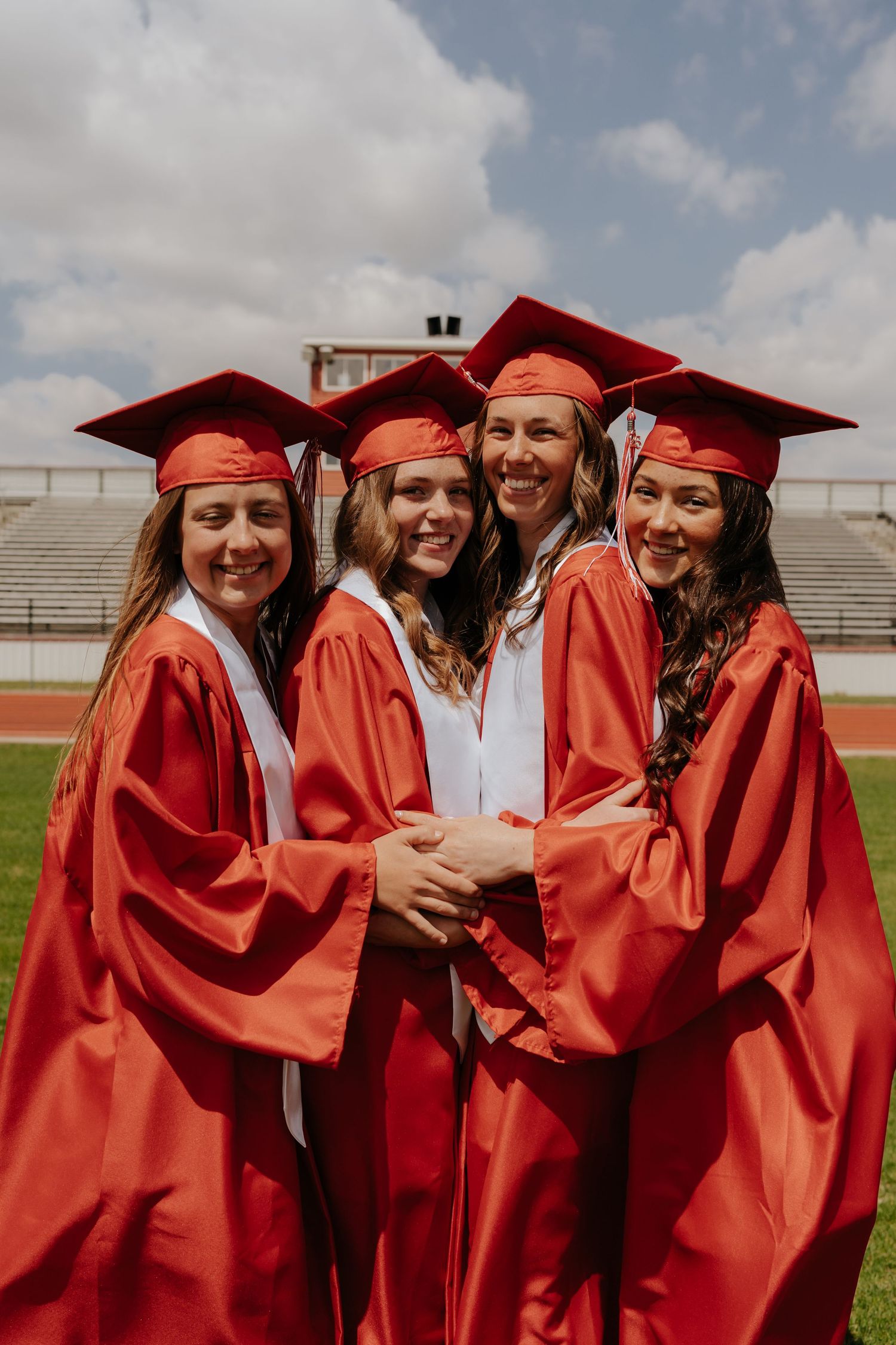 High school seniors in red cap and gown celebrating graduation — Segura Shots senior photography detroit lakes, MN