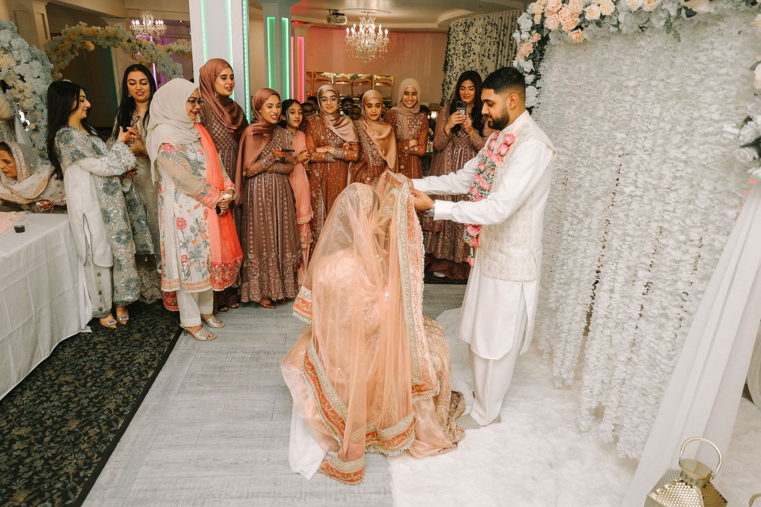 groom walking through floral entrance to meet the bride after nikah ceremony is done indoor nikah ceremony