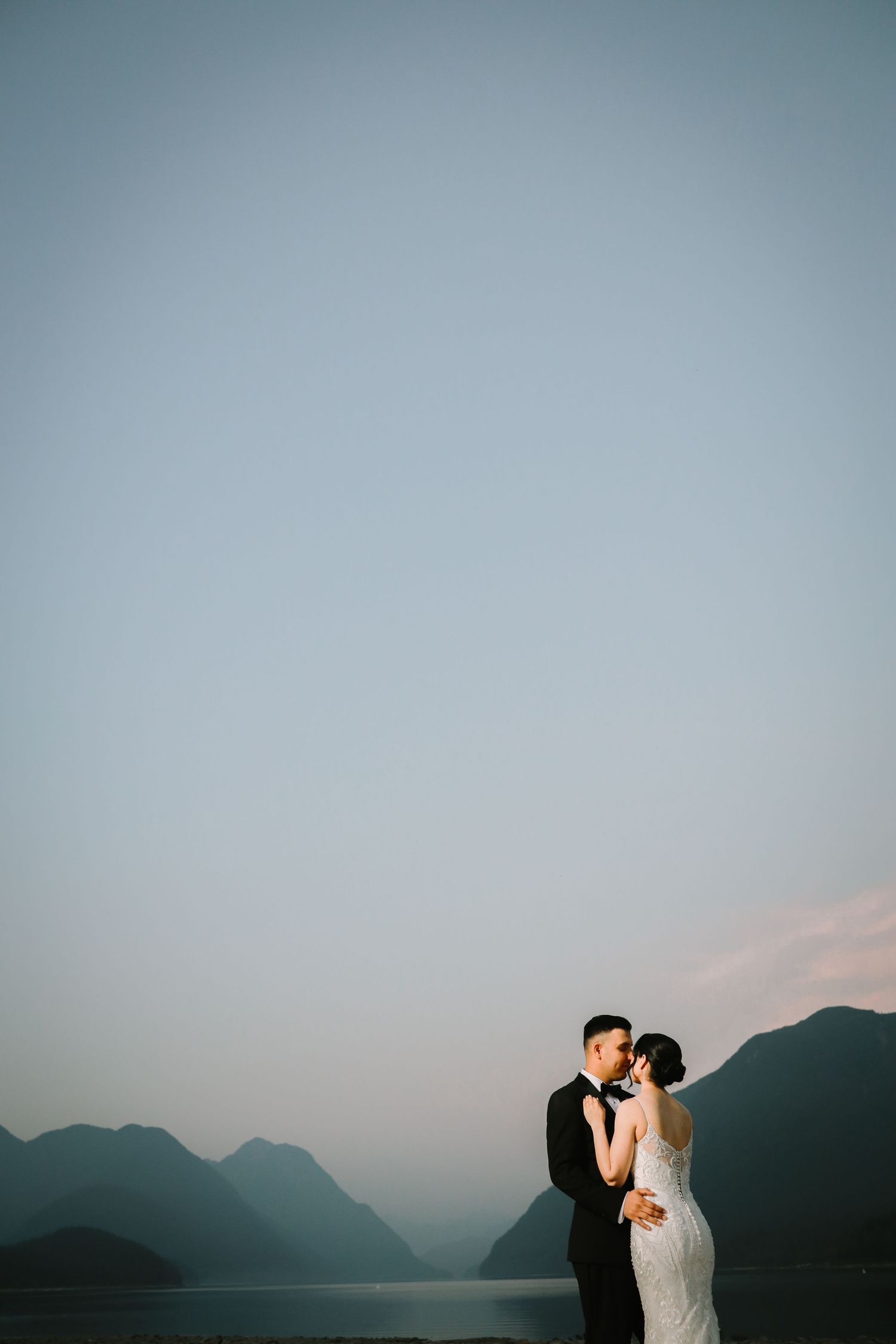 Couple embracing during pre-wedding photoshoot with mountain backdrop