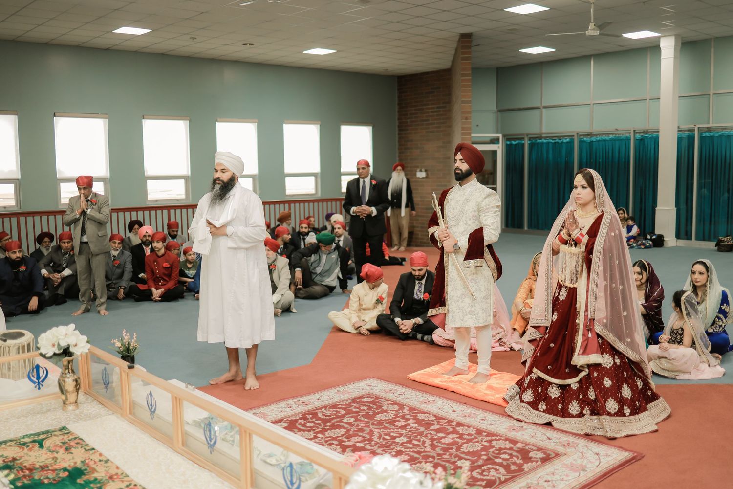 Bride and groom seated during Anand Karaj ceremony, Sikh wedding gurdwara