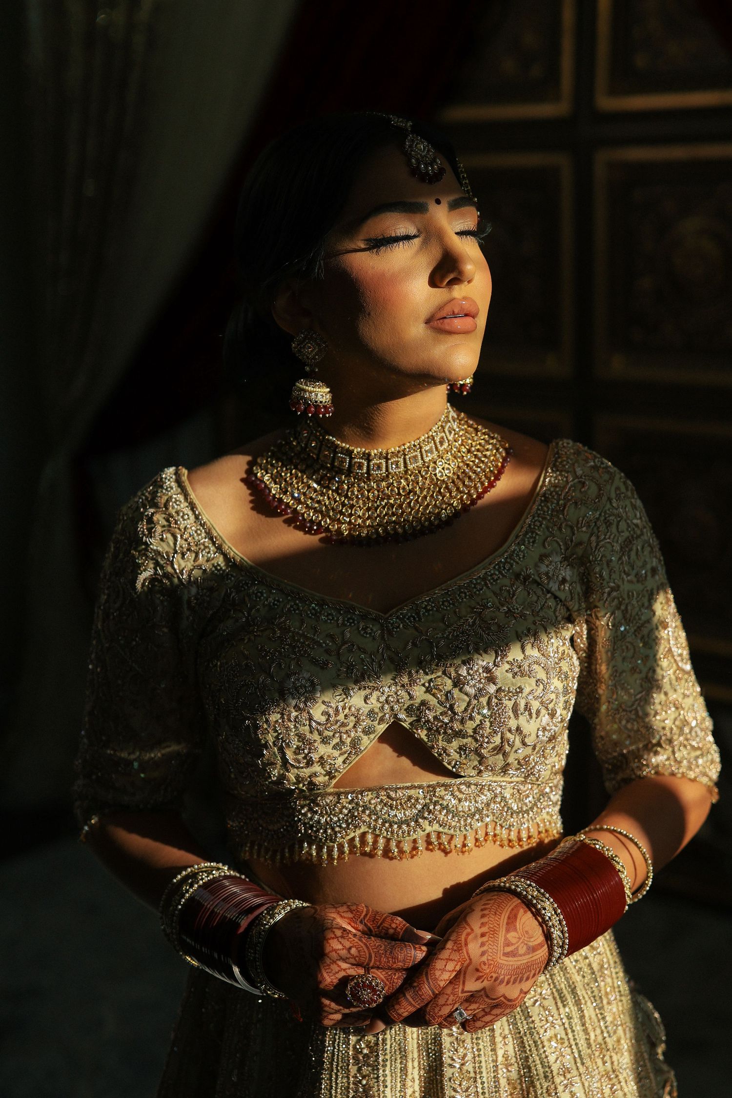 Bride in cream and gold lehenga during bridal morning portraits