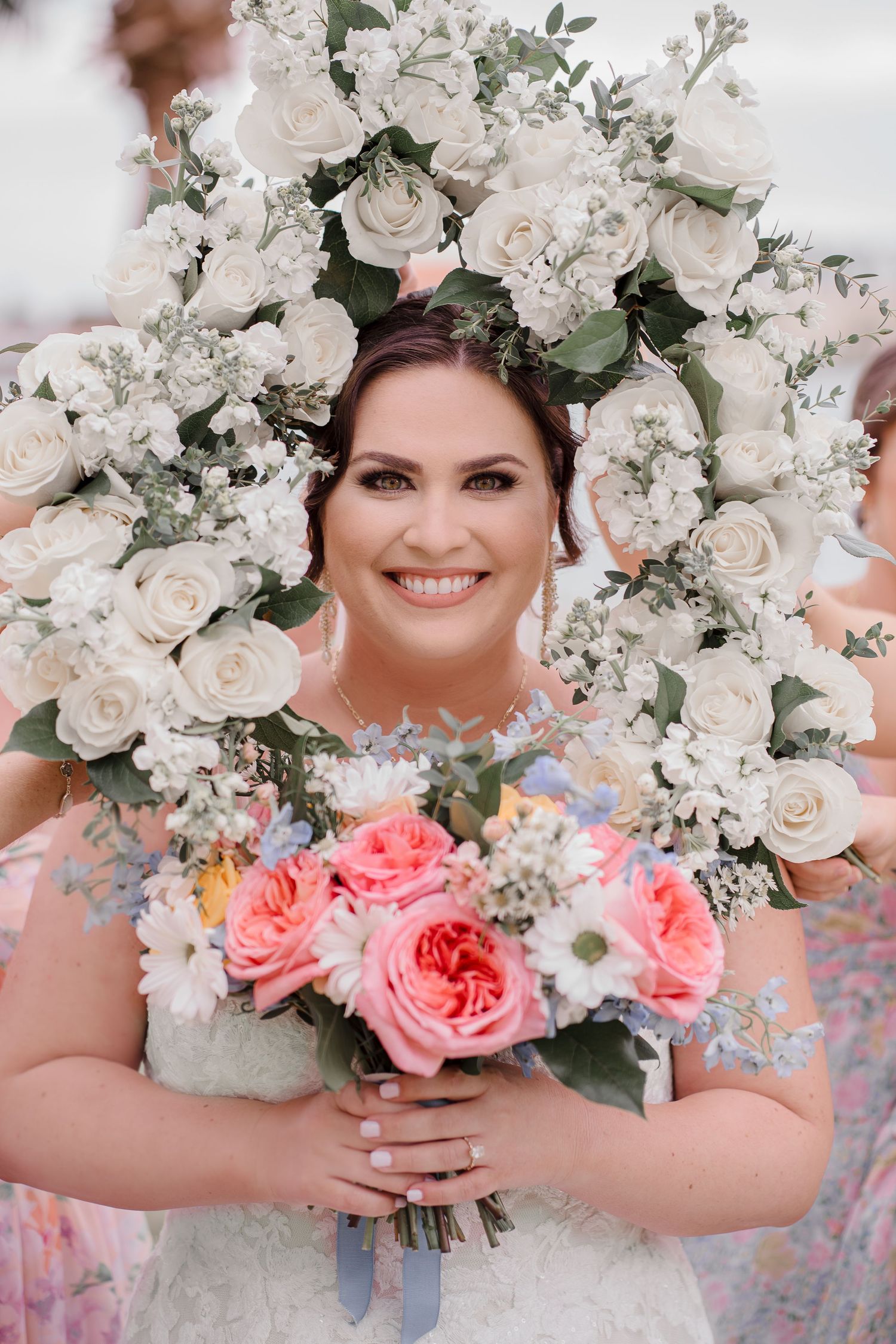 A stunning floral arrangement frames a joyful moment with white and pink roses.