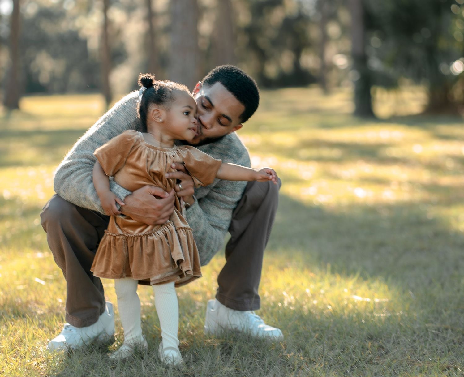 Sweet moment between parent and child playing in a sunlit park.