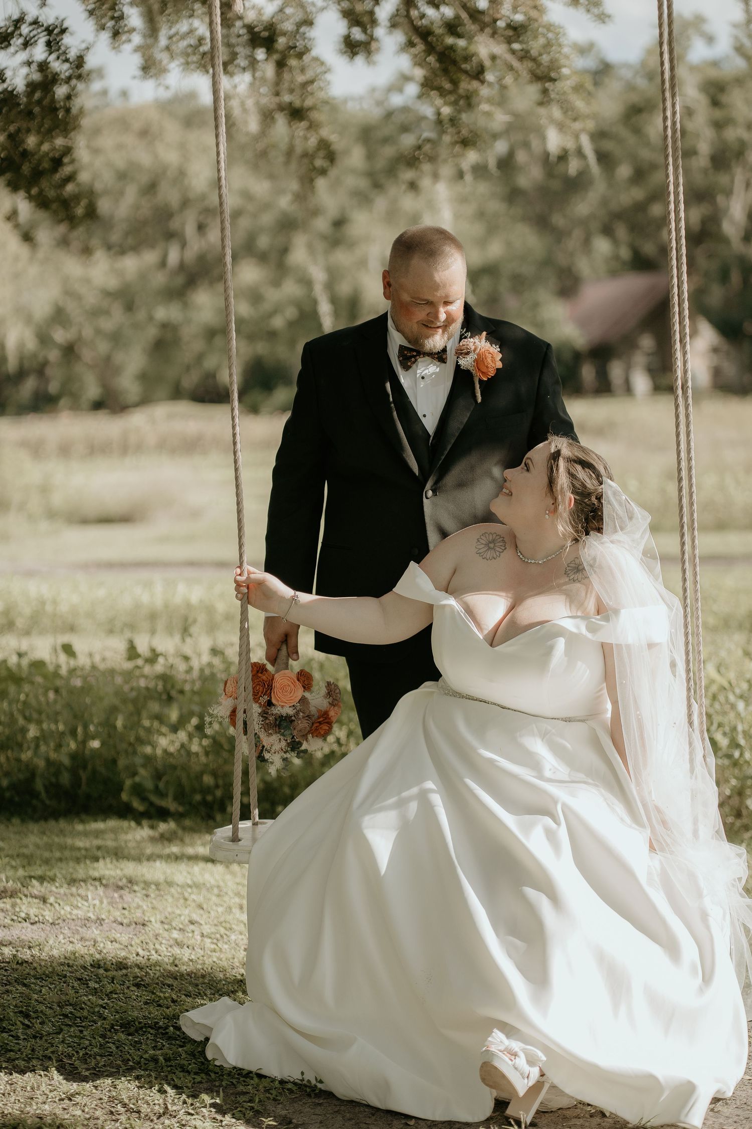 Romantic moment between newlyweds on a rustic wooden swing.