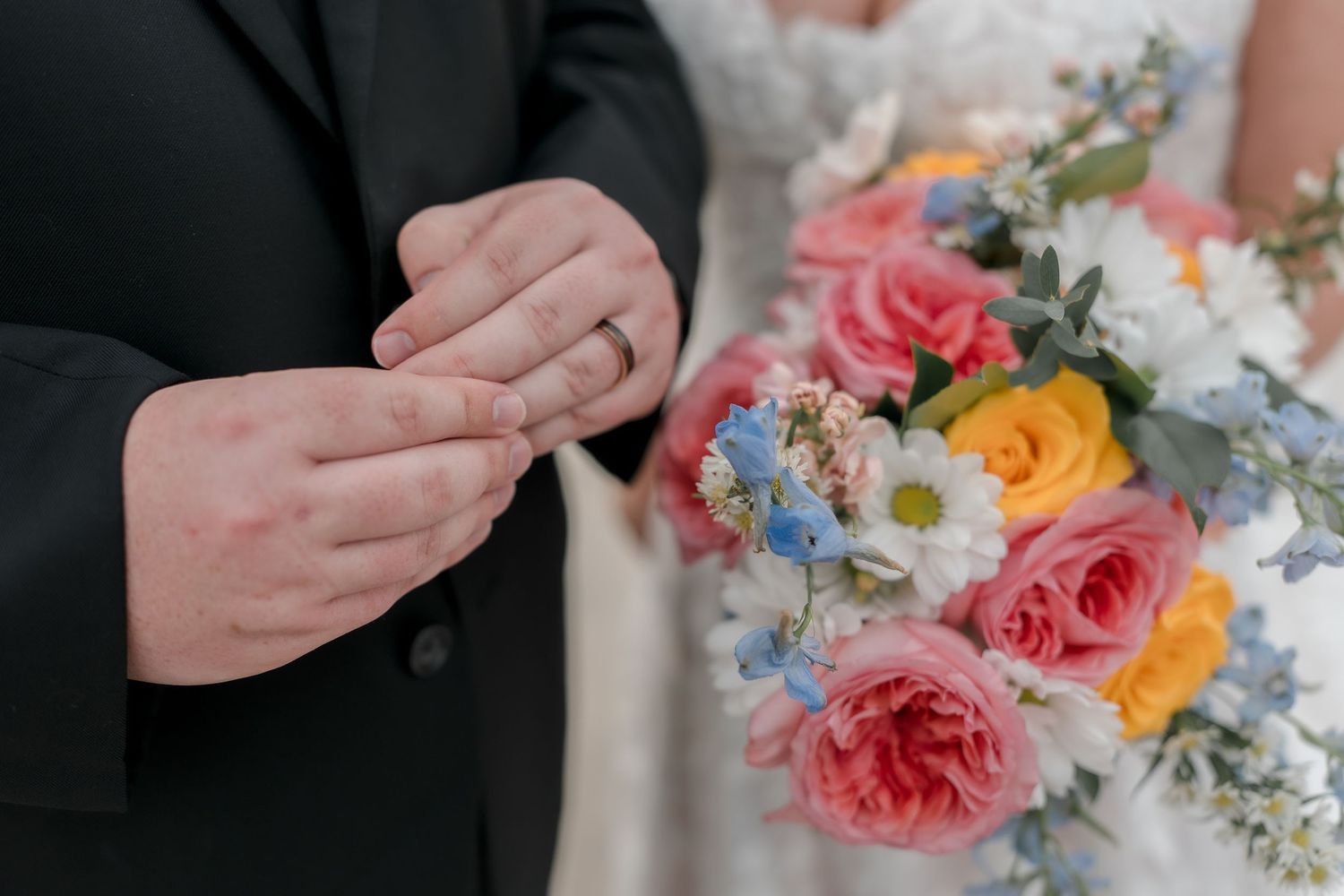 Close-up shots of colorful wedding bouquet featuring pink, orange, and blue flowers.