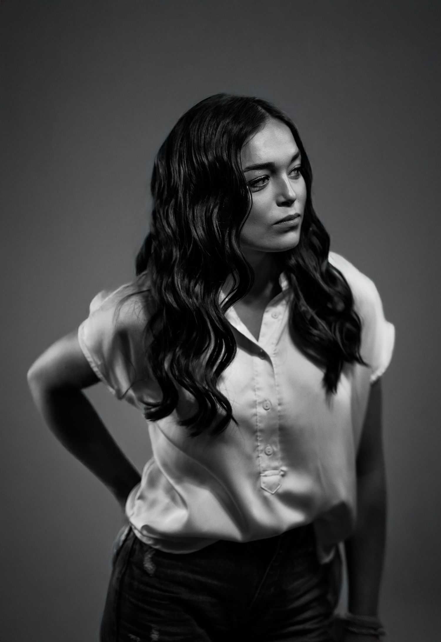 Artistic black and white portrait series showing dramatic poses against dark background.