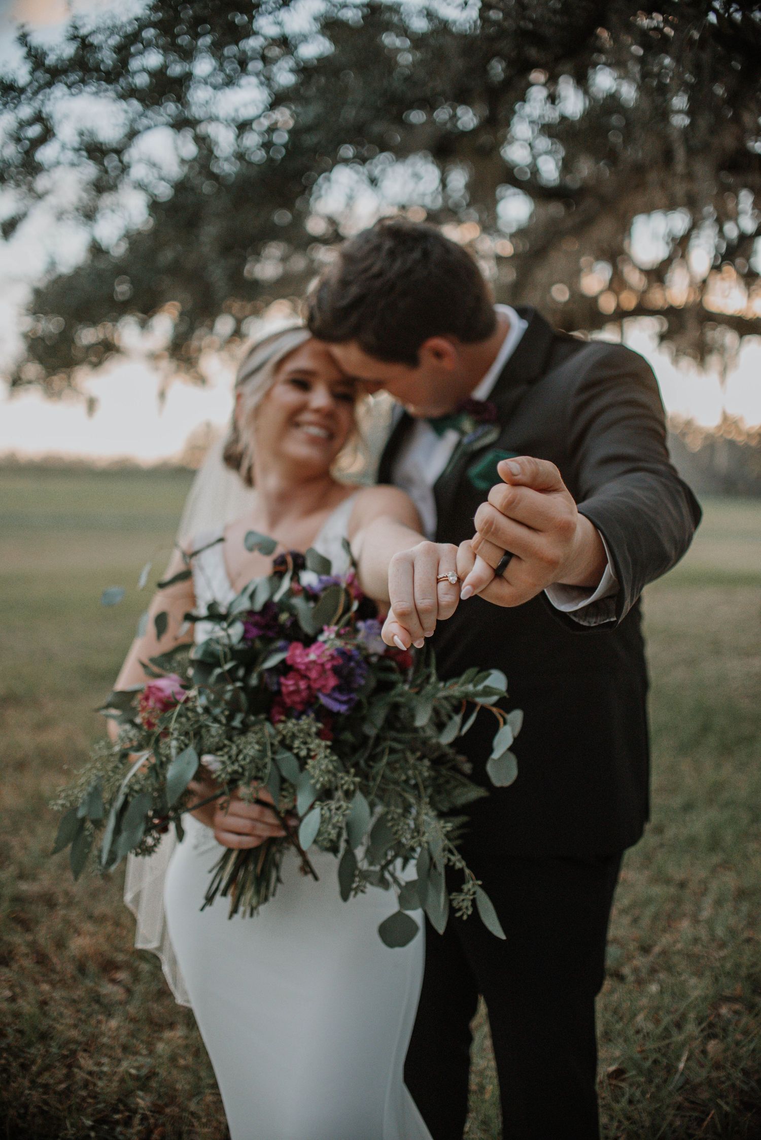 Couple interacting with floral arrangements in an outdoor garden setting during their wedding photoshoot.