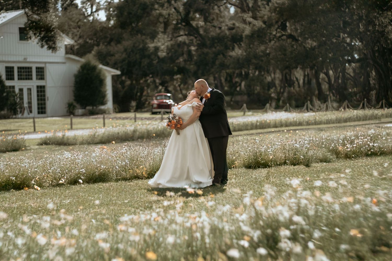 Wedding couple dances in meadow filled with spring flowers.