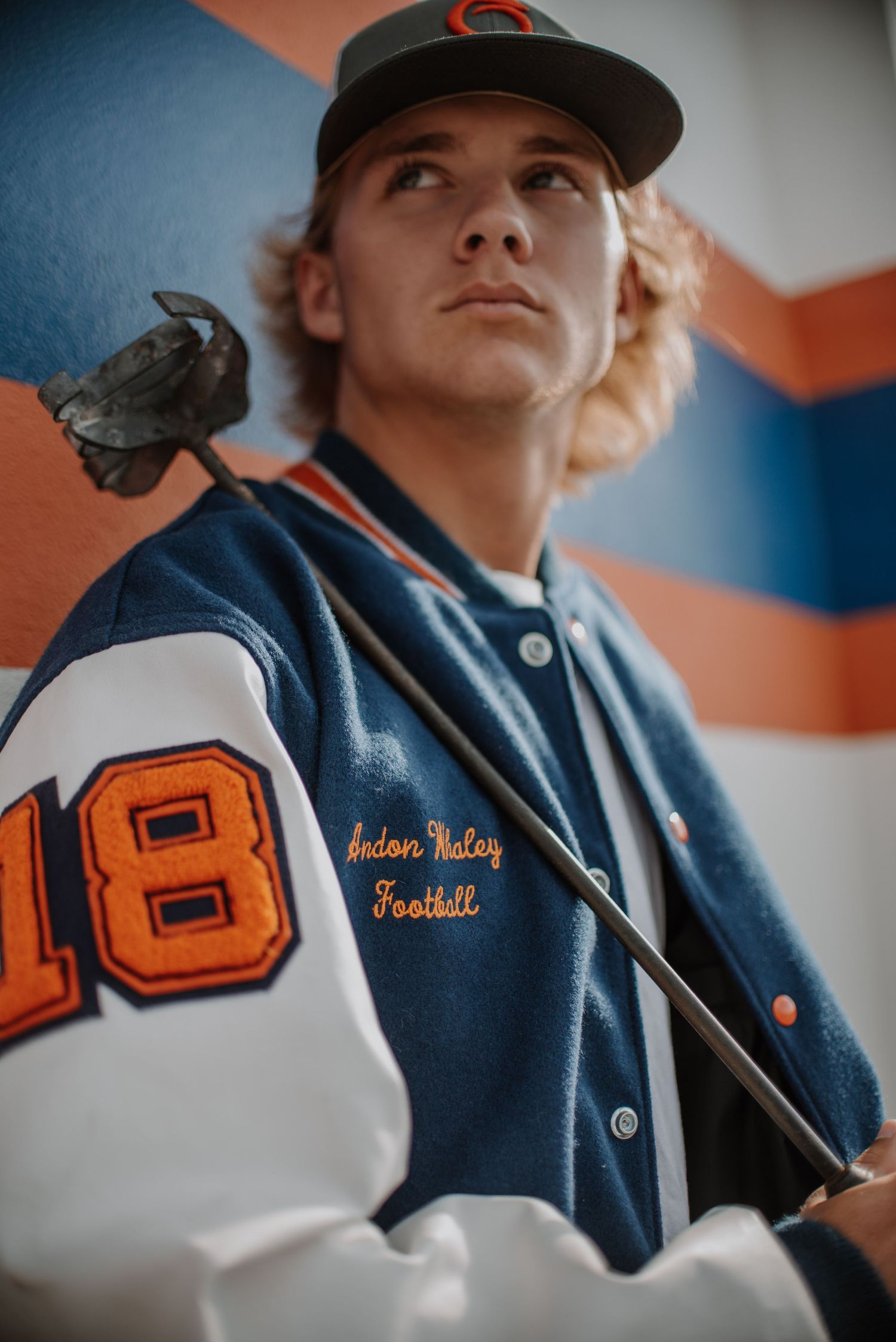 Close-up details of a navy blue baseball uniform with orange lettering and numbers.