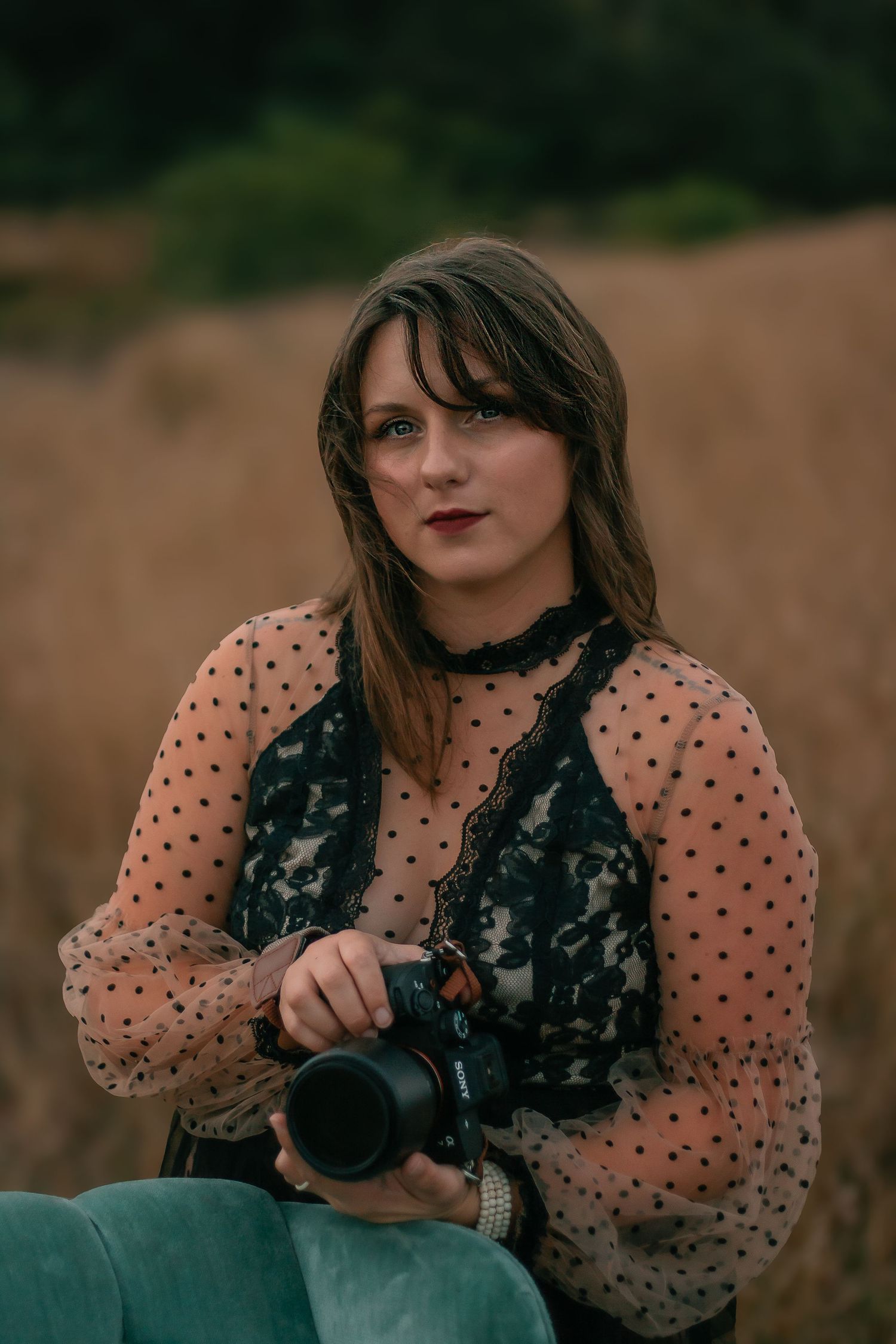 Artistic portrait series featuring polka dot sleeves and black lace details against a natural backdrop.