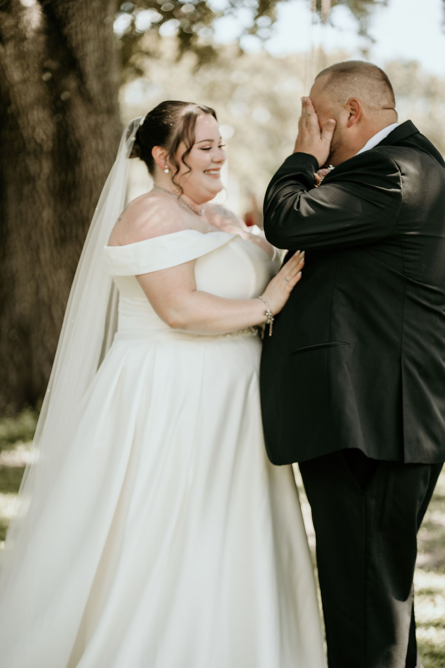 Elegant bride in flowing white gown shares romantic moments with groom during wedding ceremony.