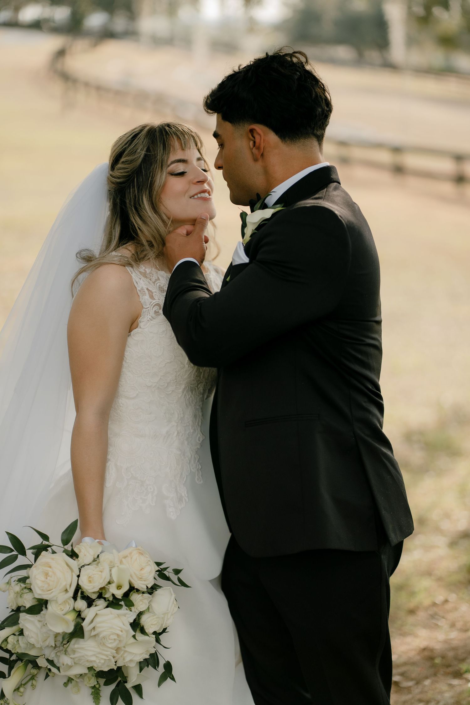 Romantic wedding couple shares intimate moments in a series of candid outdoor portraits with white floral bouquet.
