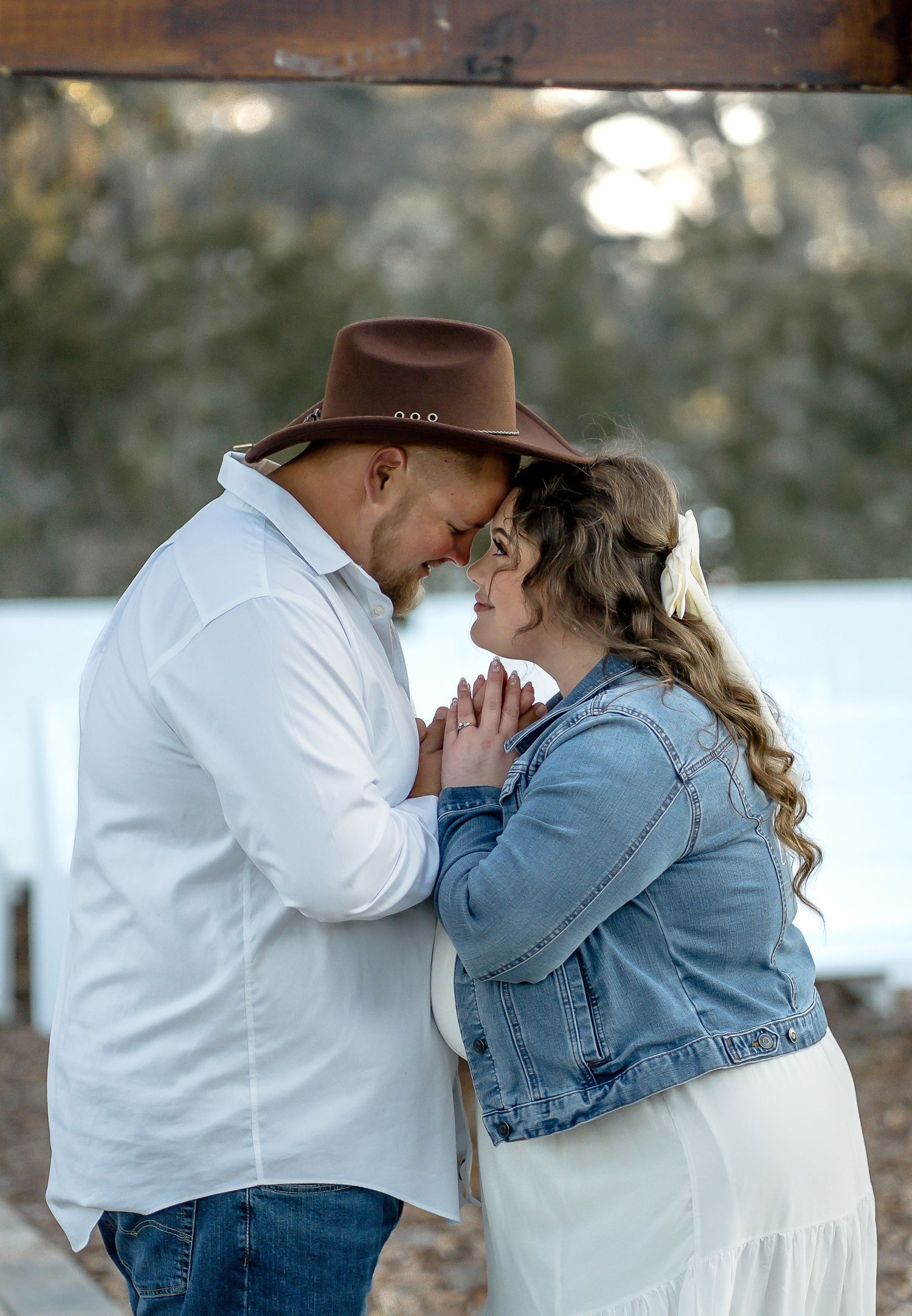 A couple shares tender moments on a tree-lined pathway at sunset.