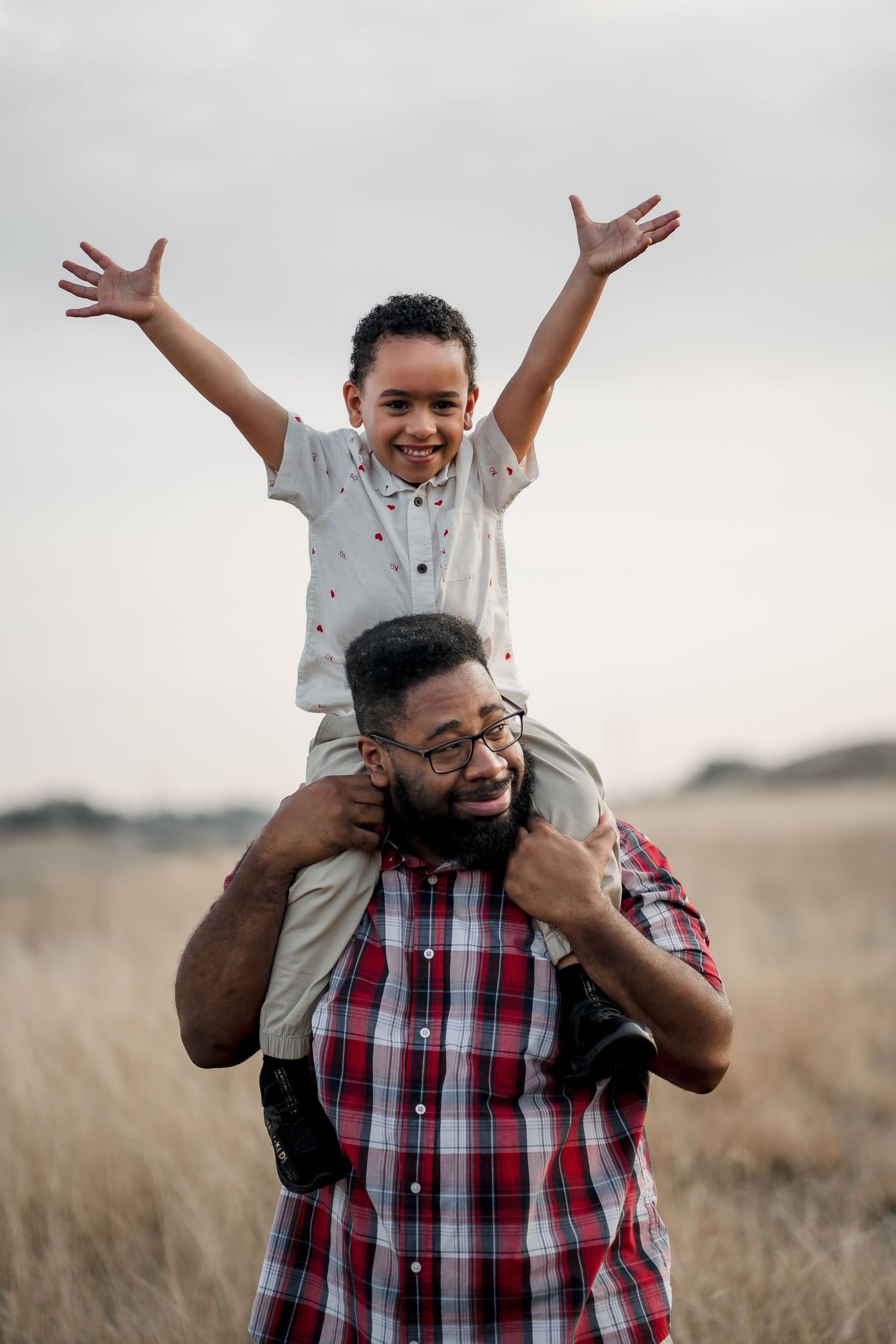 Playful father-child moments captured in a field during golden hour.