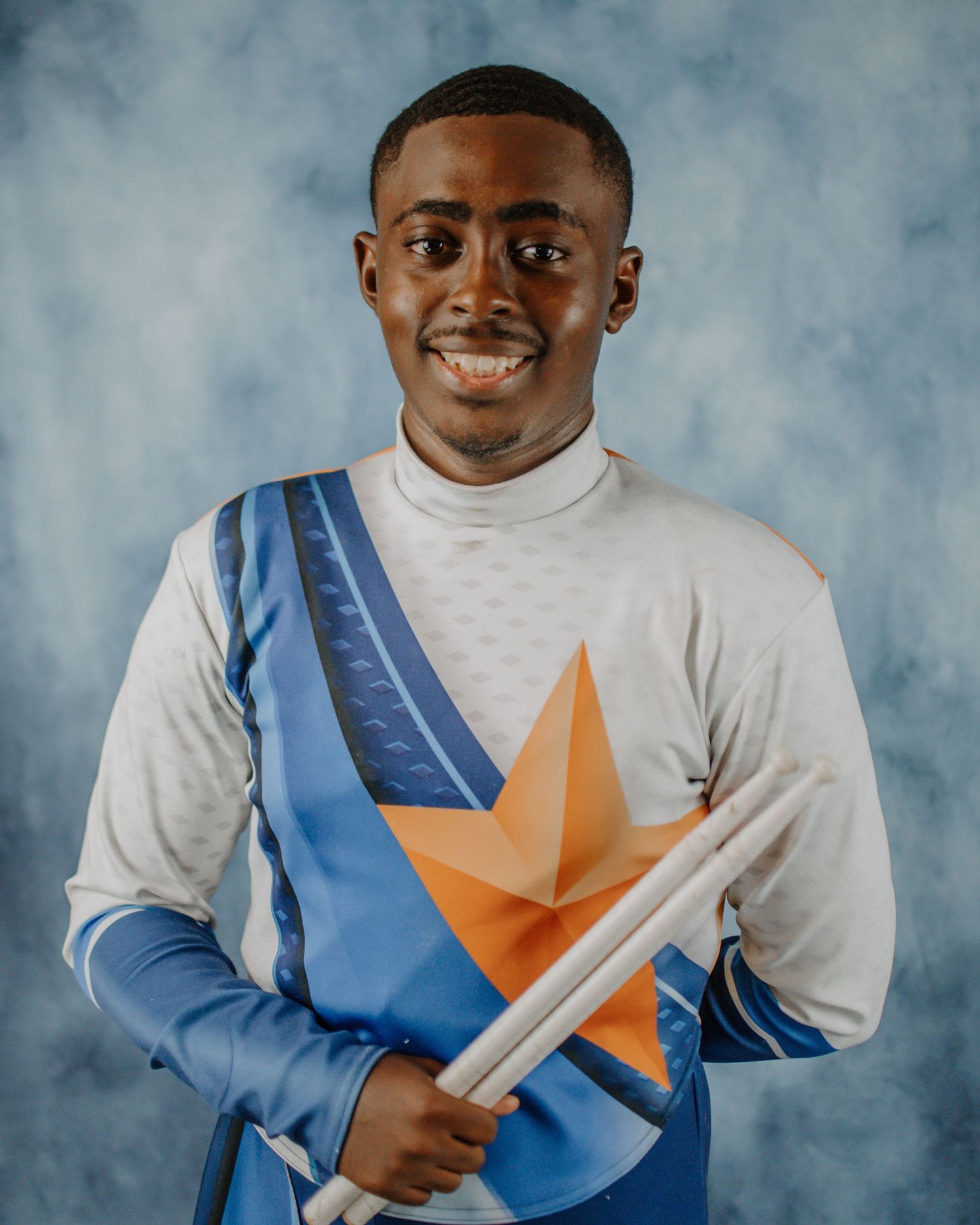 A series of portraits showing someone in a white shirt with blue and orange sash against a cloudy backdrop.
