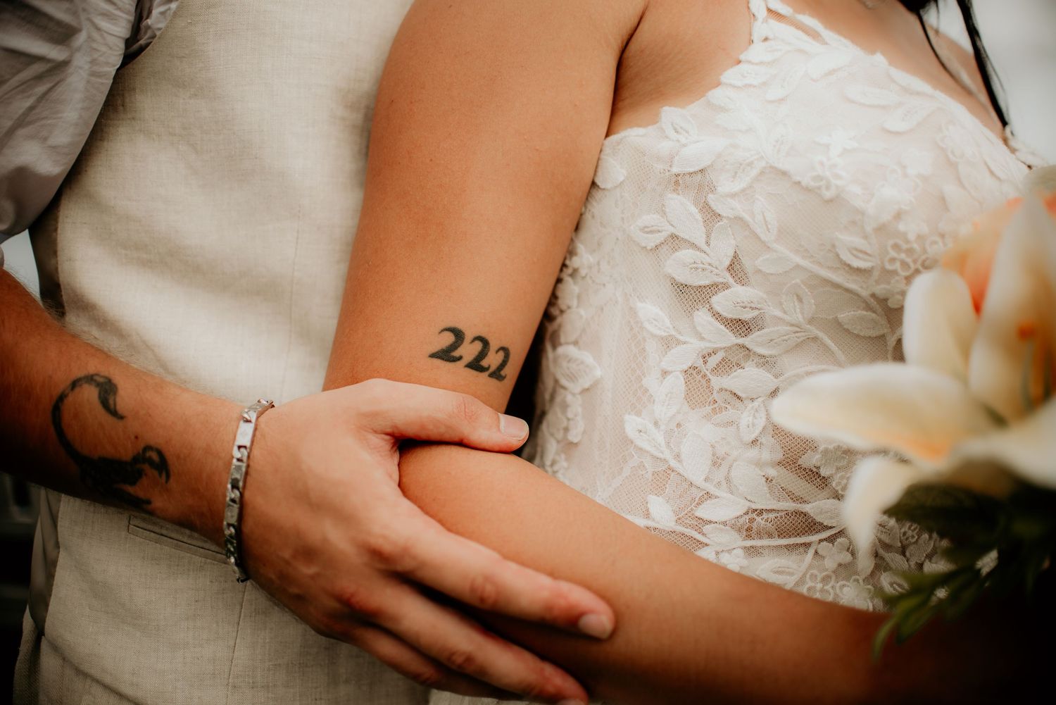 Close-up detail of wedding attire showing tattoo and lace dress.