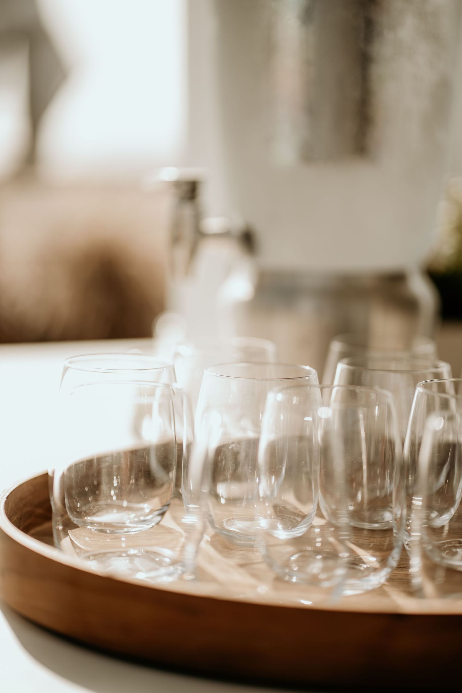 Empty wine glasses arranged on wooden serving tray at wedding reception.
