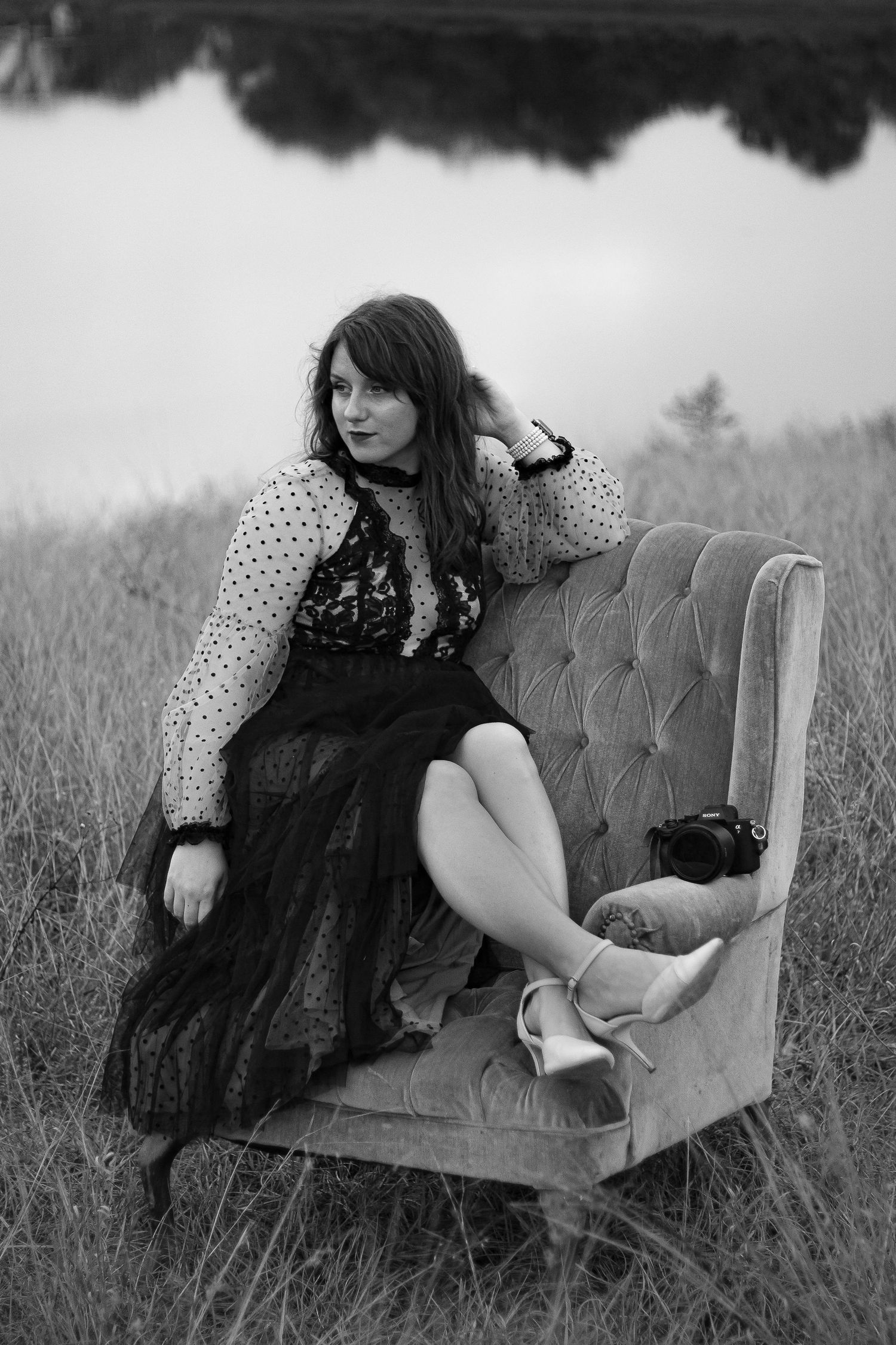 Artistic portrait session featuring a teal velvet couch in a natural outdoor setting.