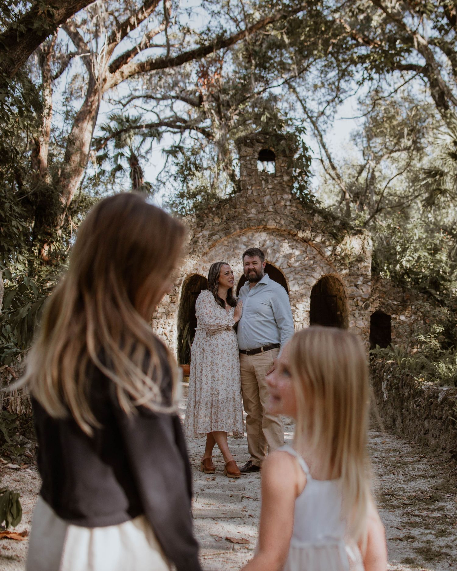 Outdoor gathering with people watching a special moment under moss-draped trees.