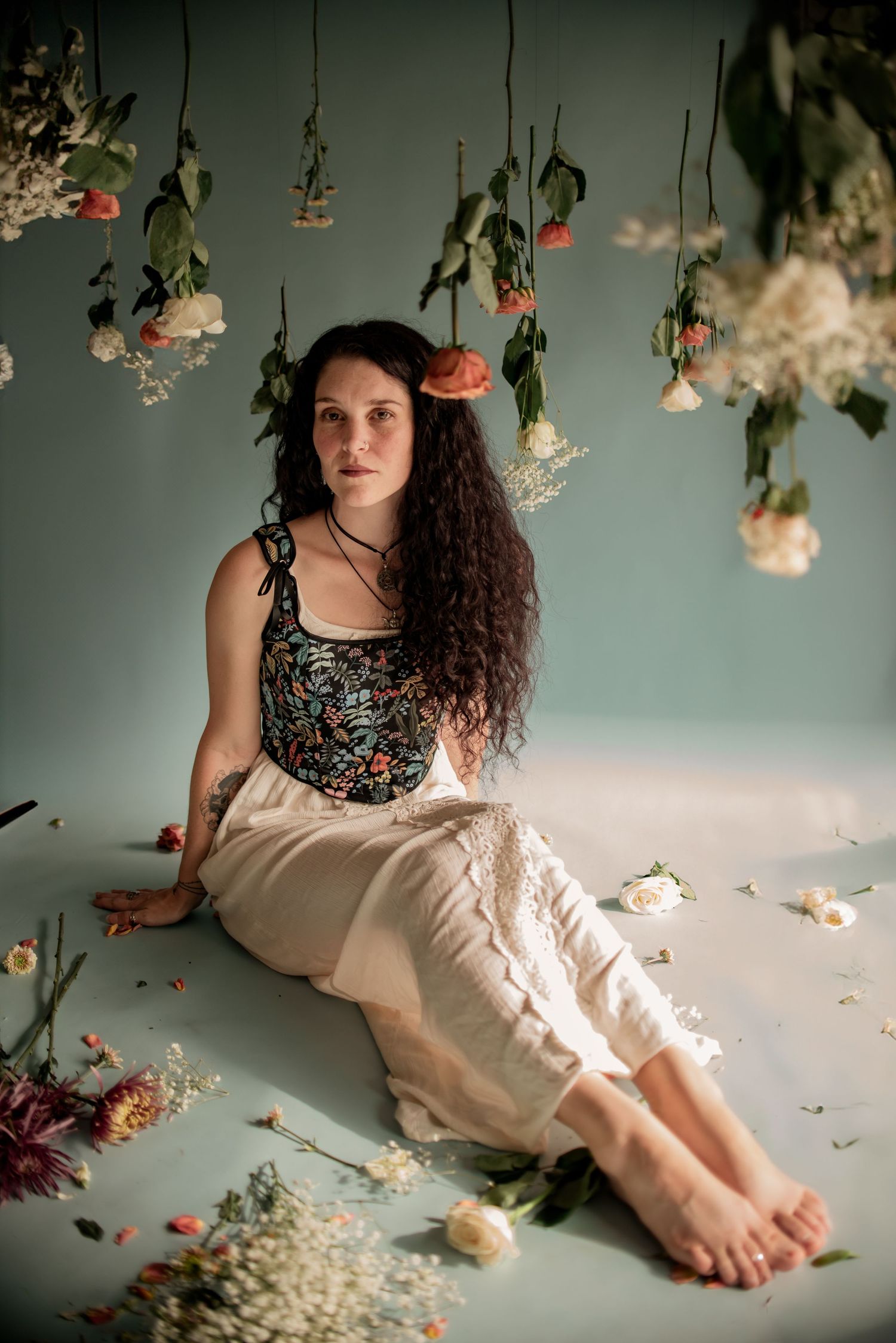 Artistic portrait with hanging dried flowers and a dreamy atmosphere.