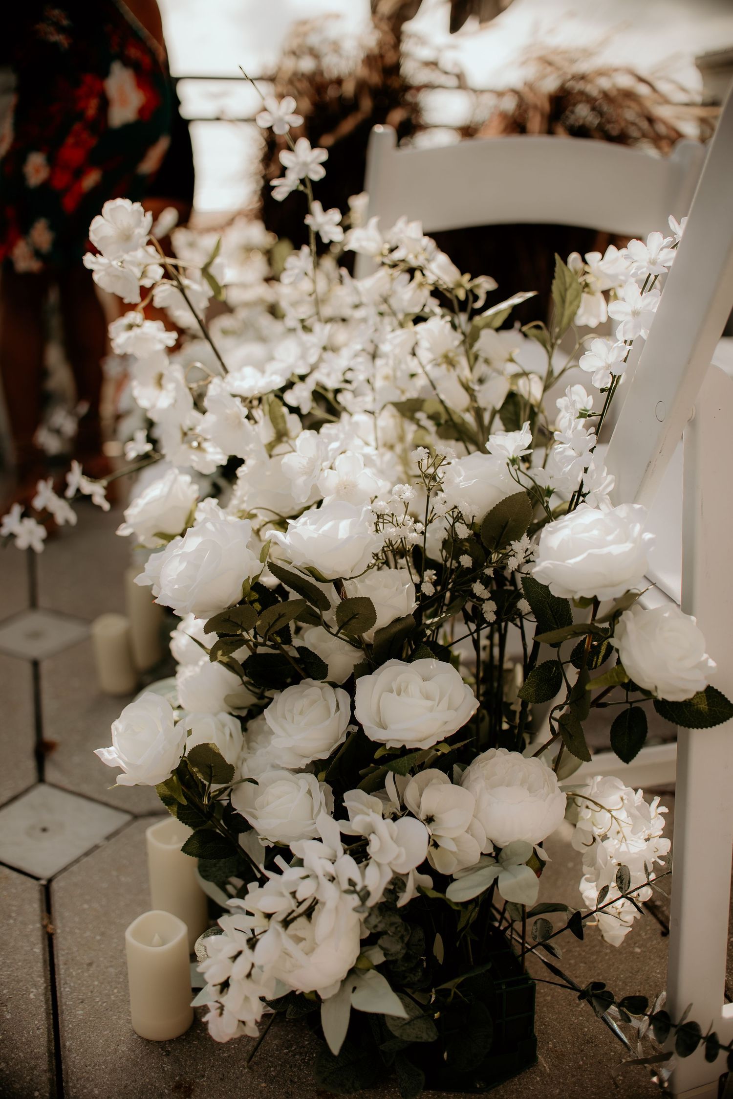 Elegant white floral centerpiece arrangement with roses and greenery on display.