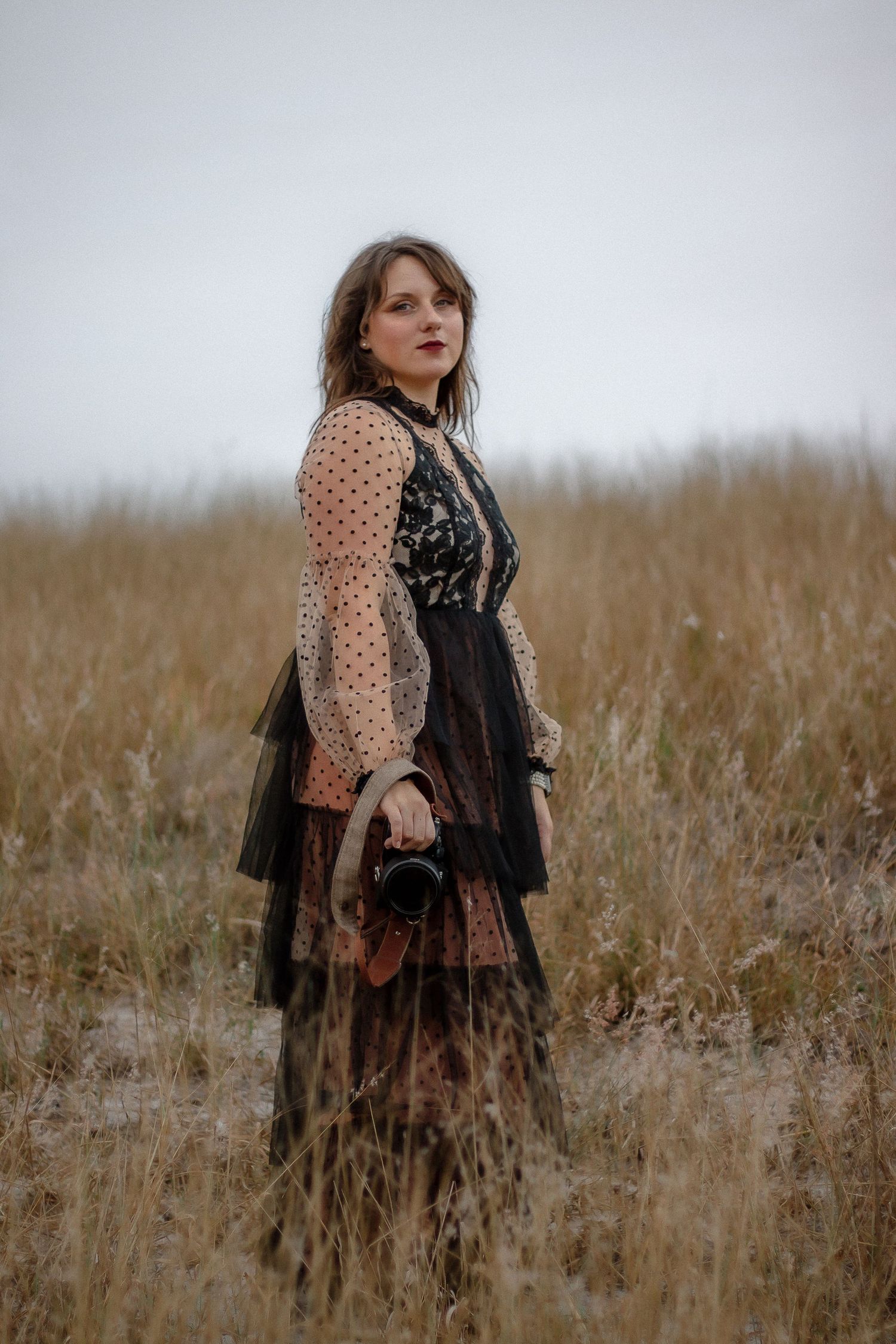 A dreamy outdoor fashion scene with polka dot sleeves and black lace details.