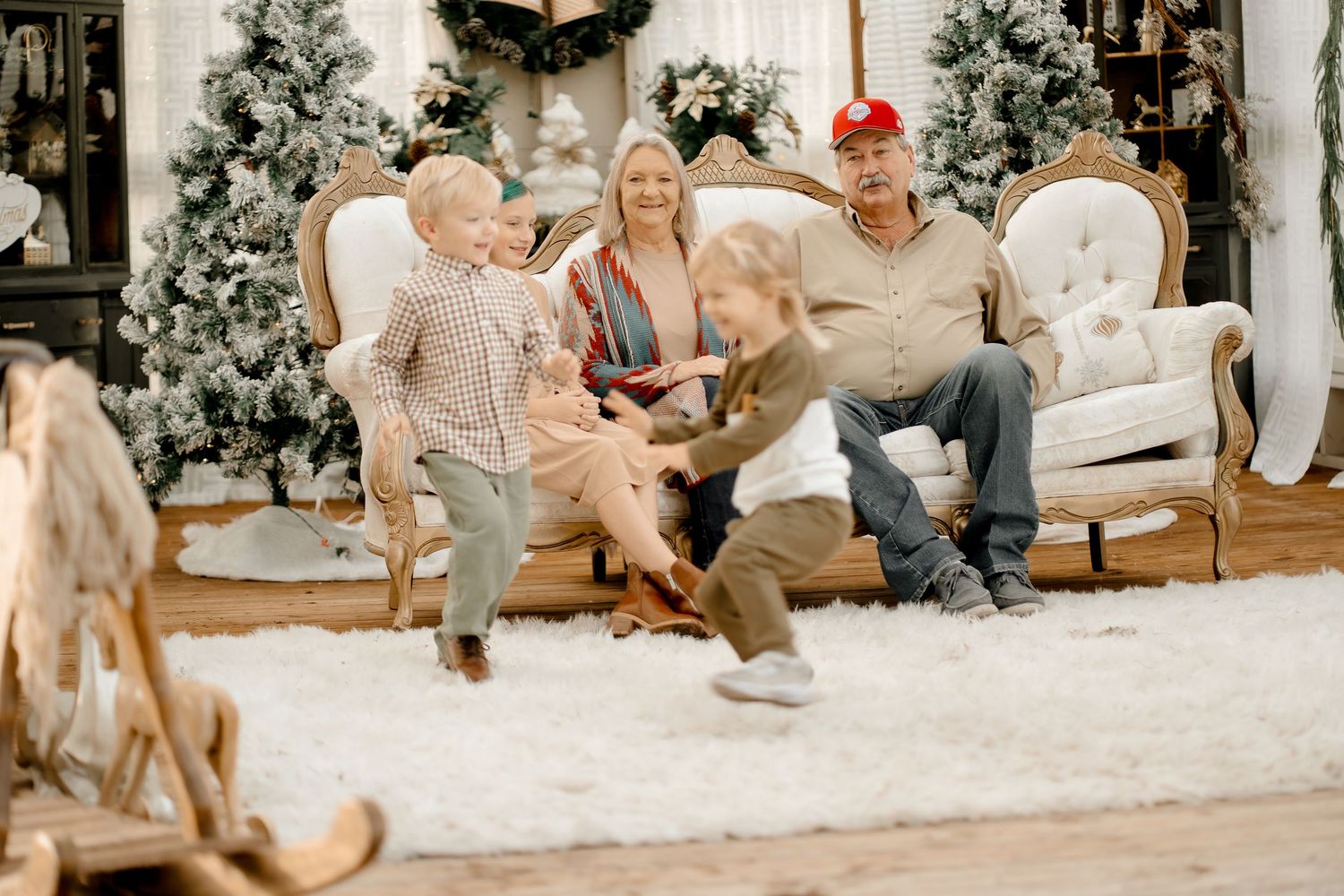 Family gathering in a cozy living room decorated with Christmas trees and holiday decor during winter celebrations.
