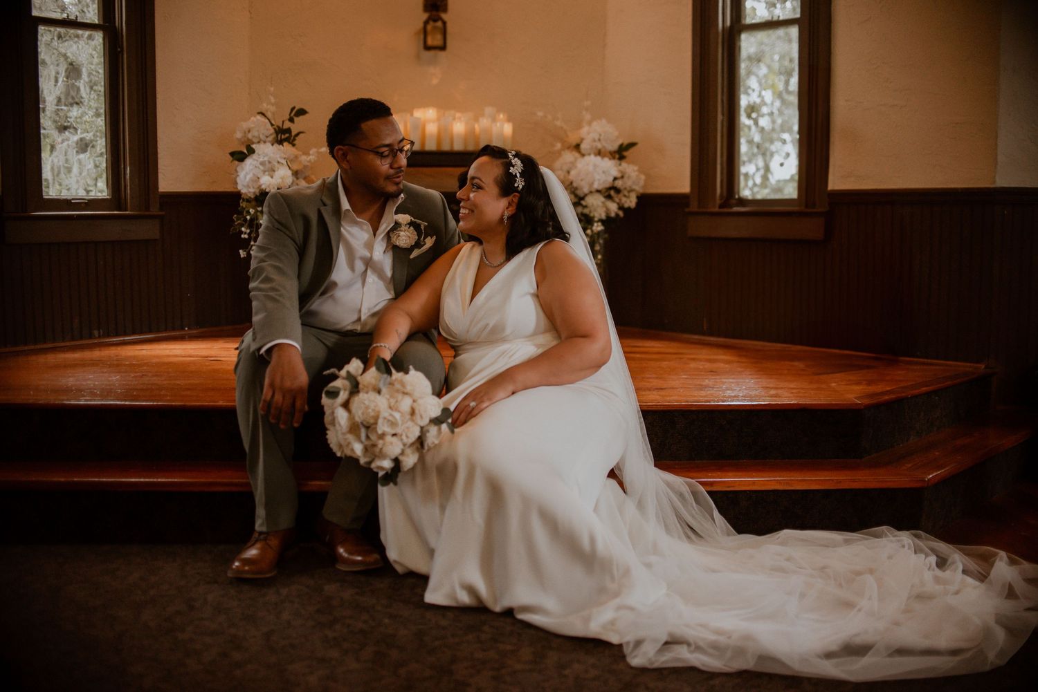 Intimate wedding ceremony moment in a warm-lit chapel interior.