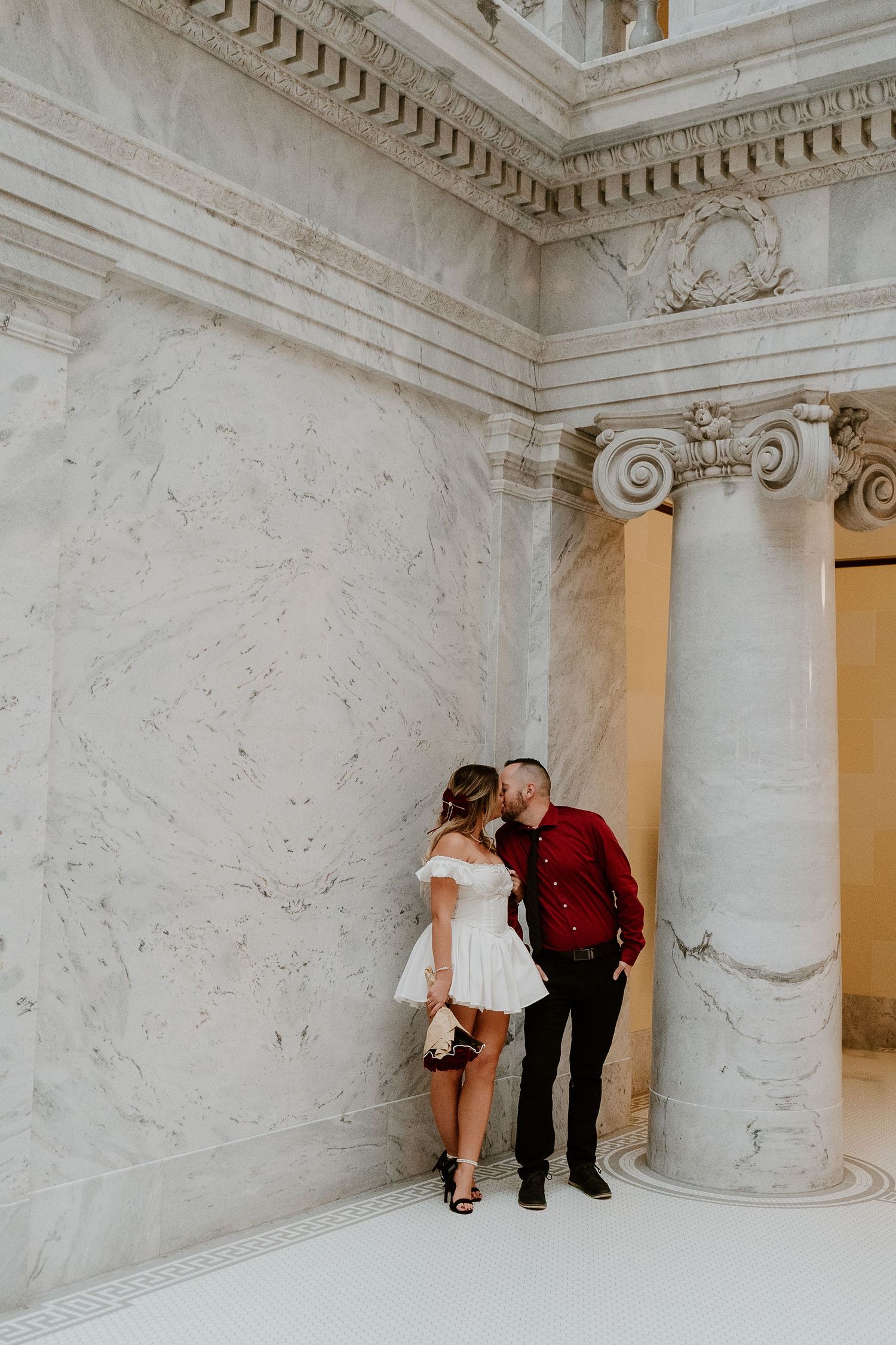 Couple embracing inside Utah State Capitol during romantic portrait session