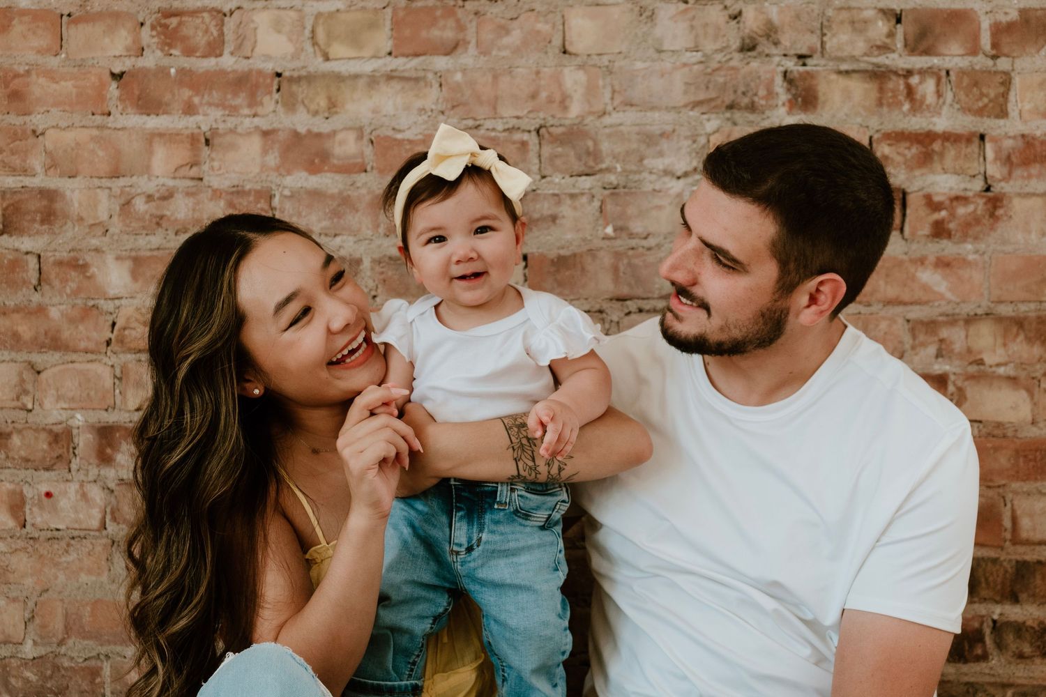 Parents holding baby girl during warm indoor family photo session