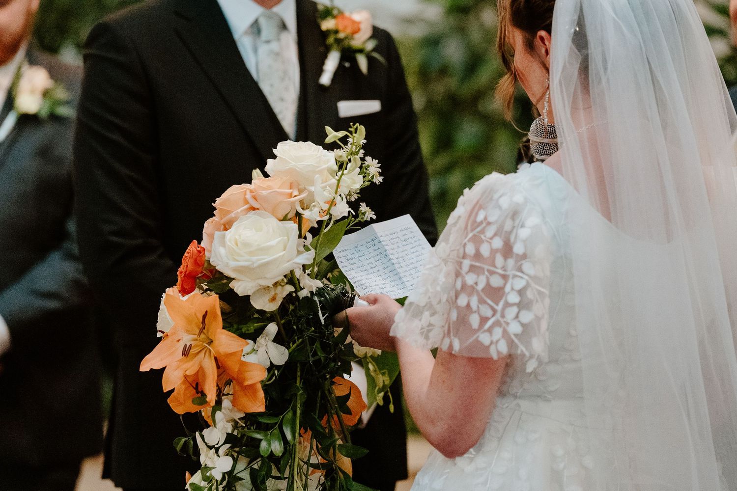 Bride and groom holding bouquet during intimate wedding ceremony vows