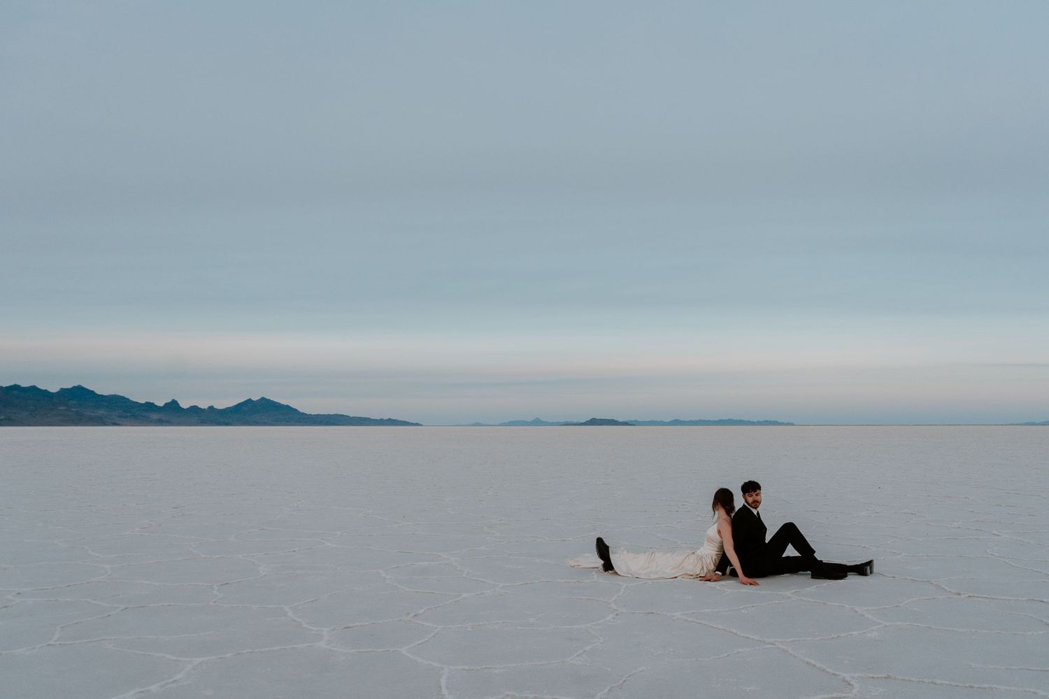 Couple back to back at Bonneville Salt Flats during Utah couples photography session