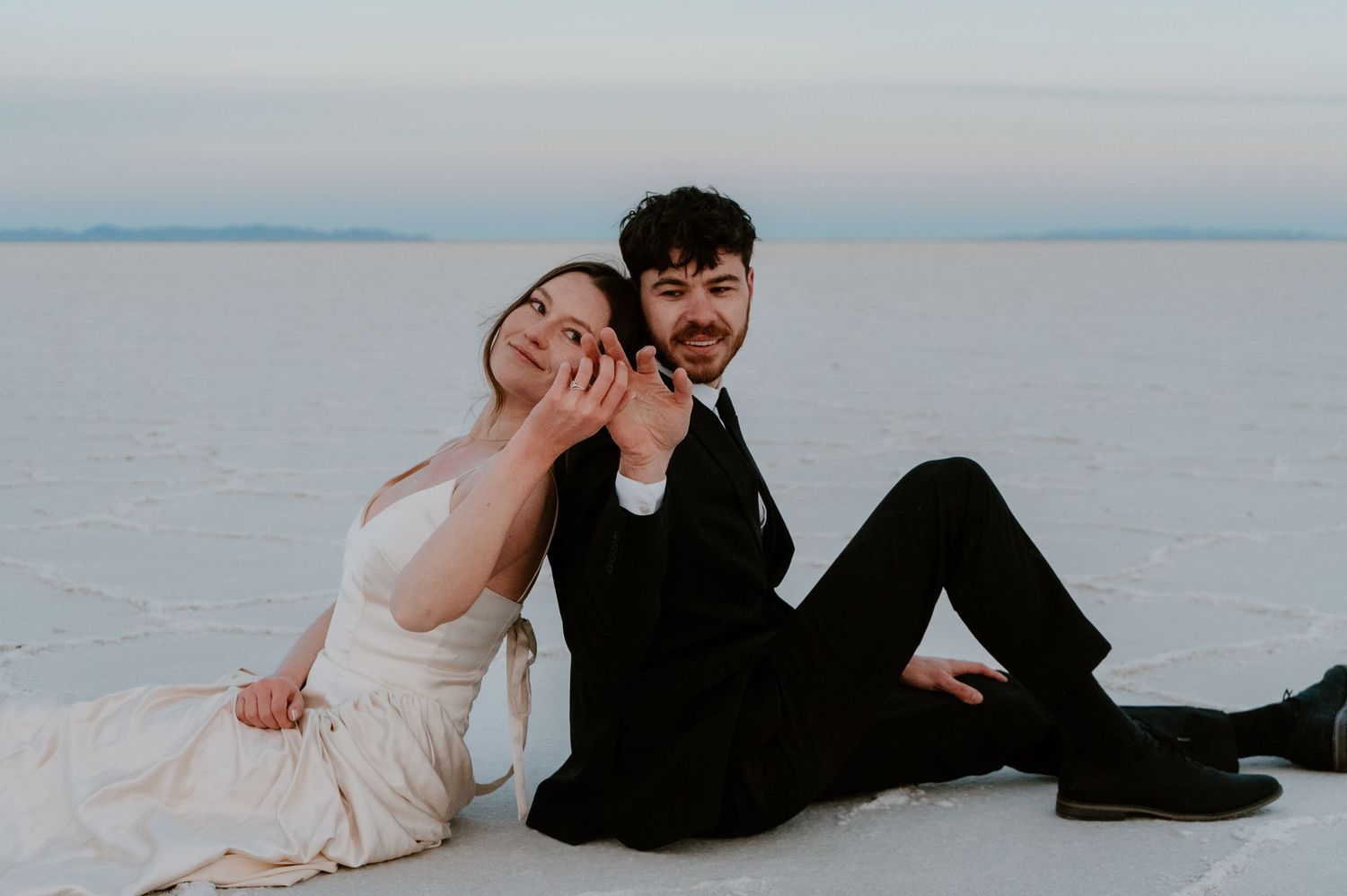 Couple touching hands during romantic Salt Flats photo session in Utah