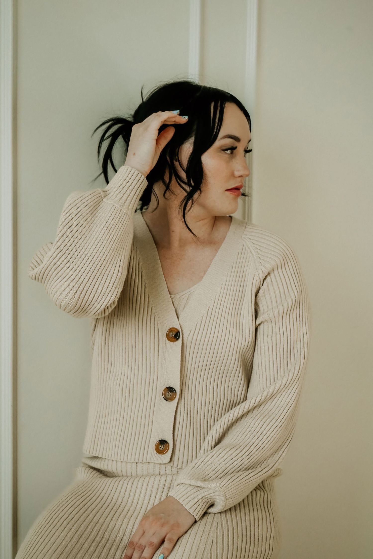 Woman posing indoors in neutral sweater during lifestyle branding session
