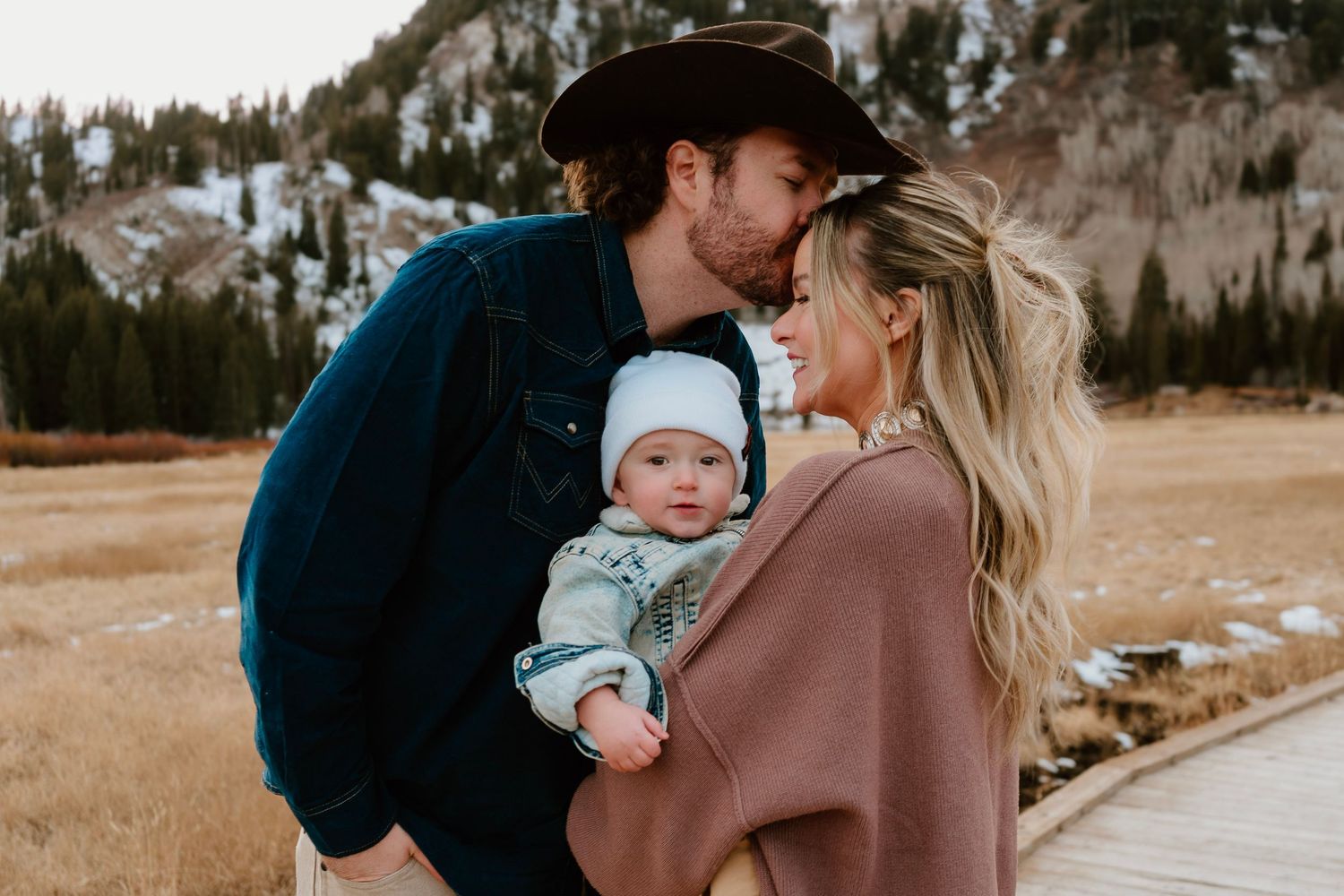 Young family portrait in Utah mountains with parents holding baby outdoors