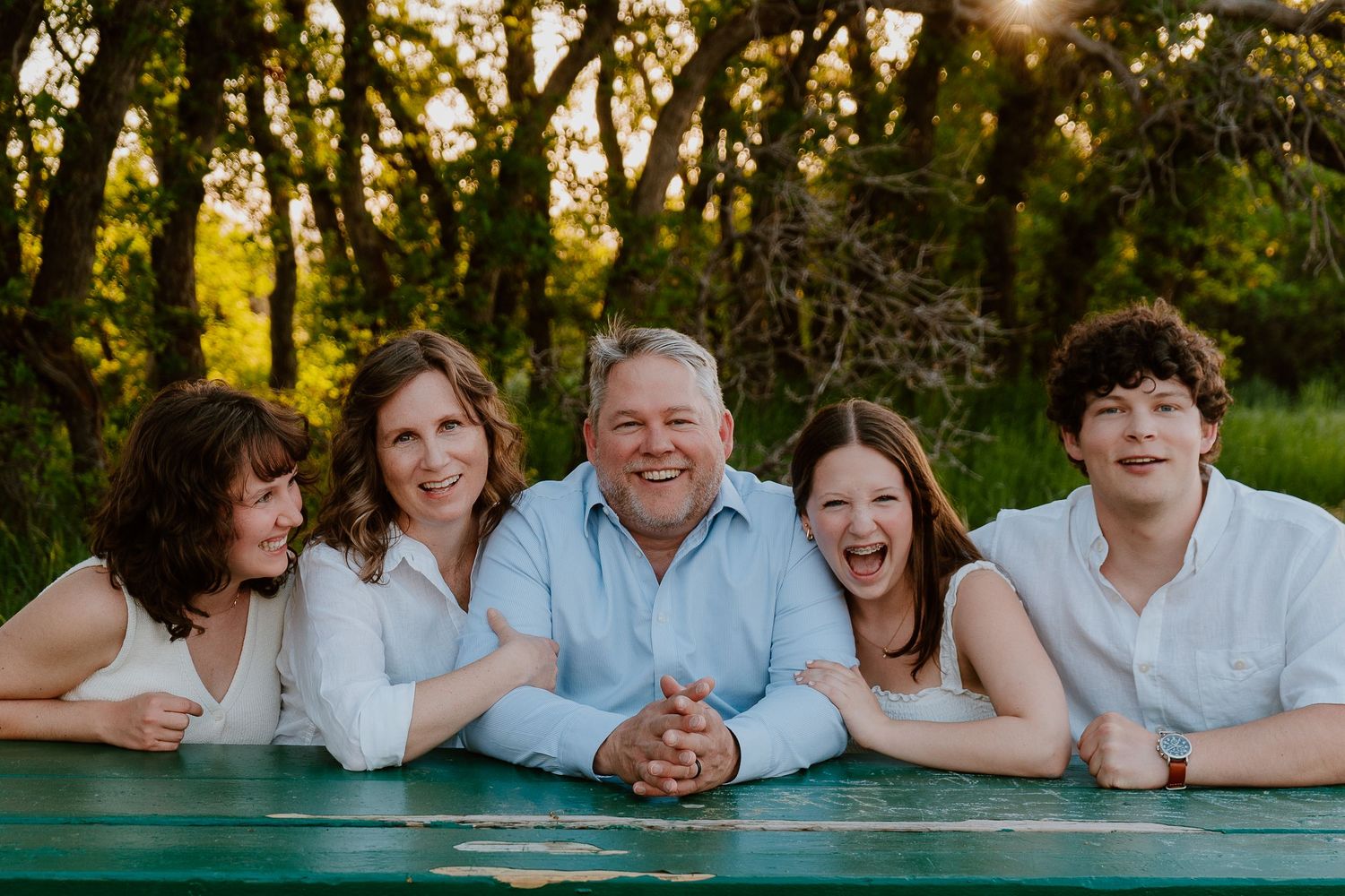 Family of five smiling together outdoors during relaxed family photo session