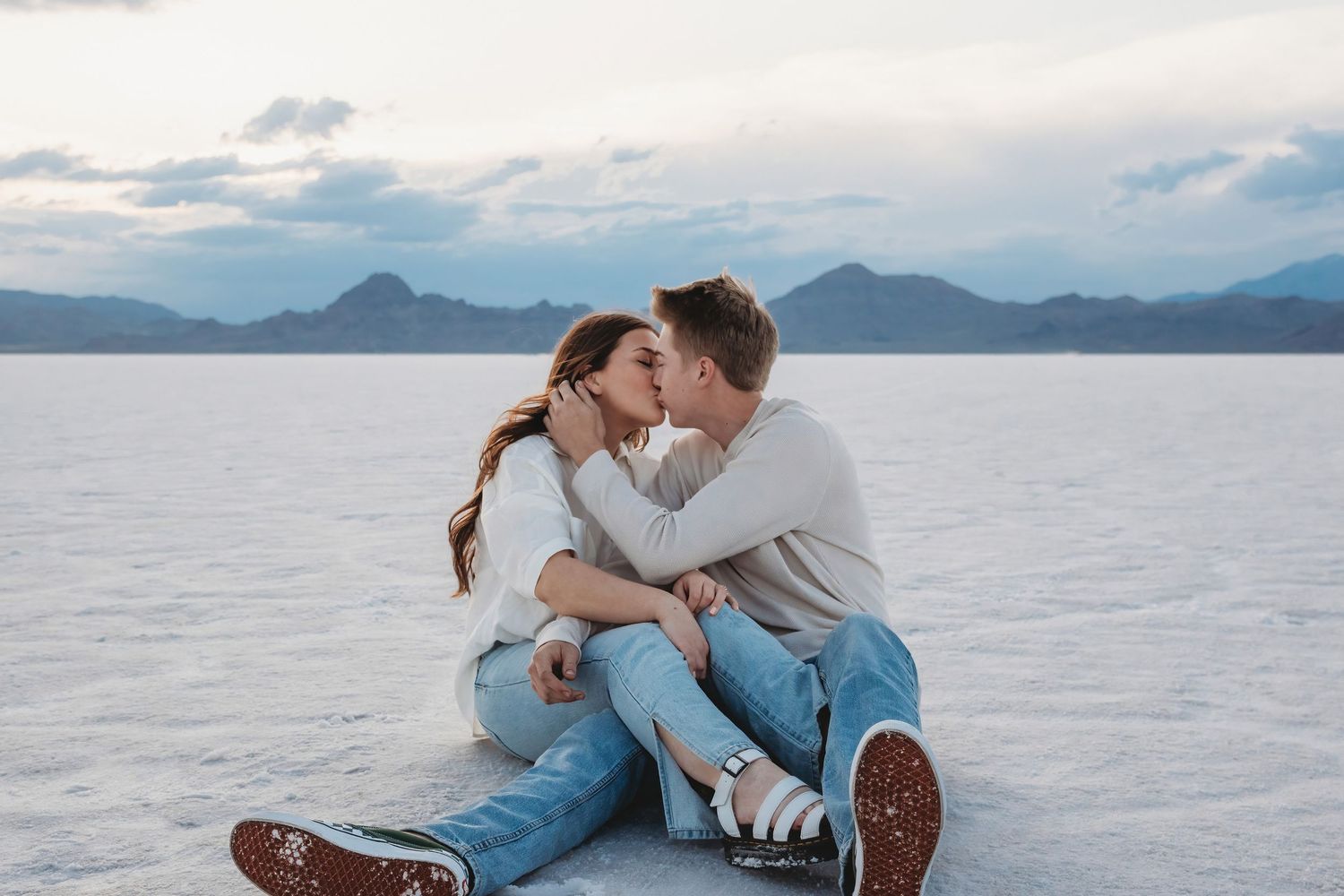 Couple kissing while seated at Bonneville Salt Flats during Utah session